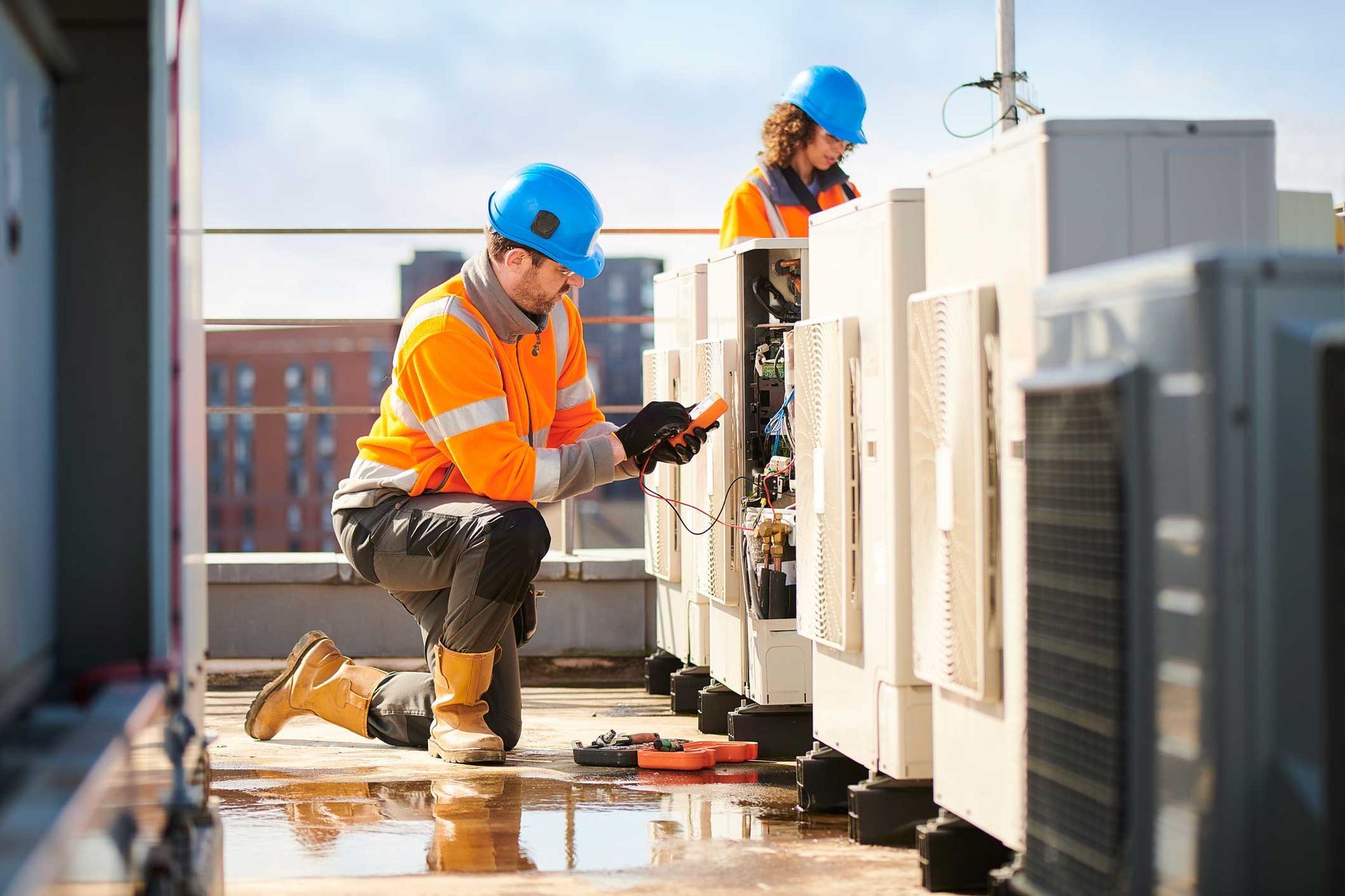 A man and a woman are working on a rooftop.