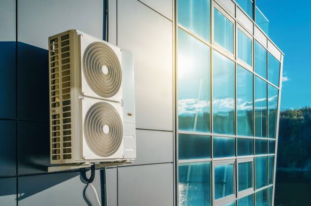 A large air conditioner is mounted on the side of a building.