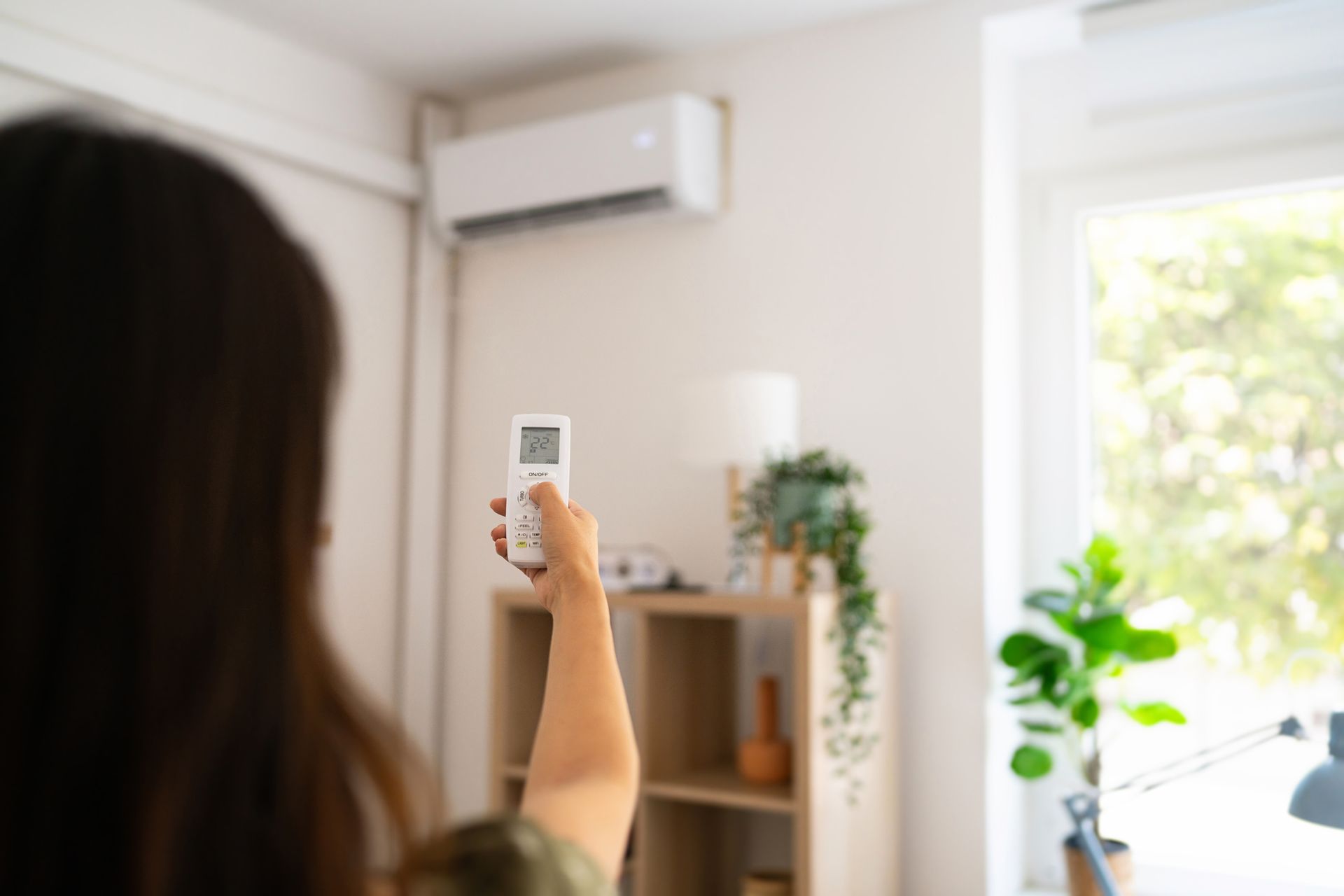 A woman is holding a remote control in a living room.