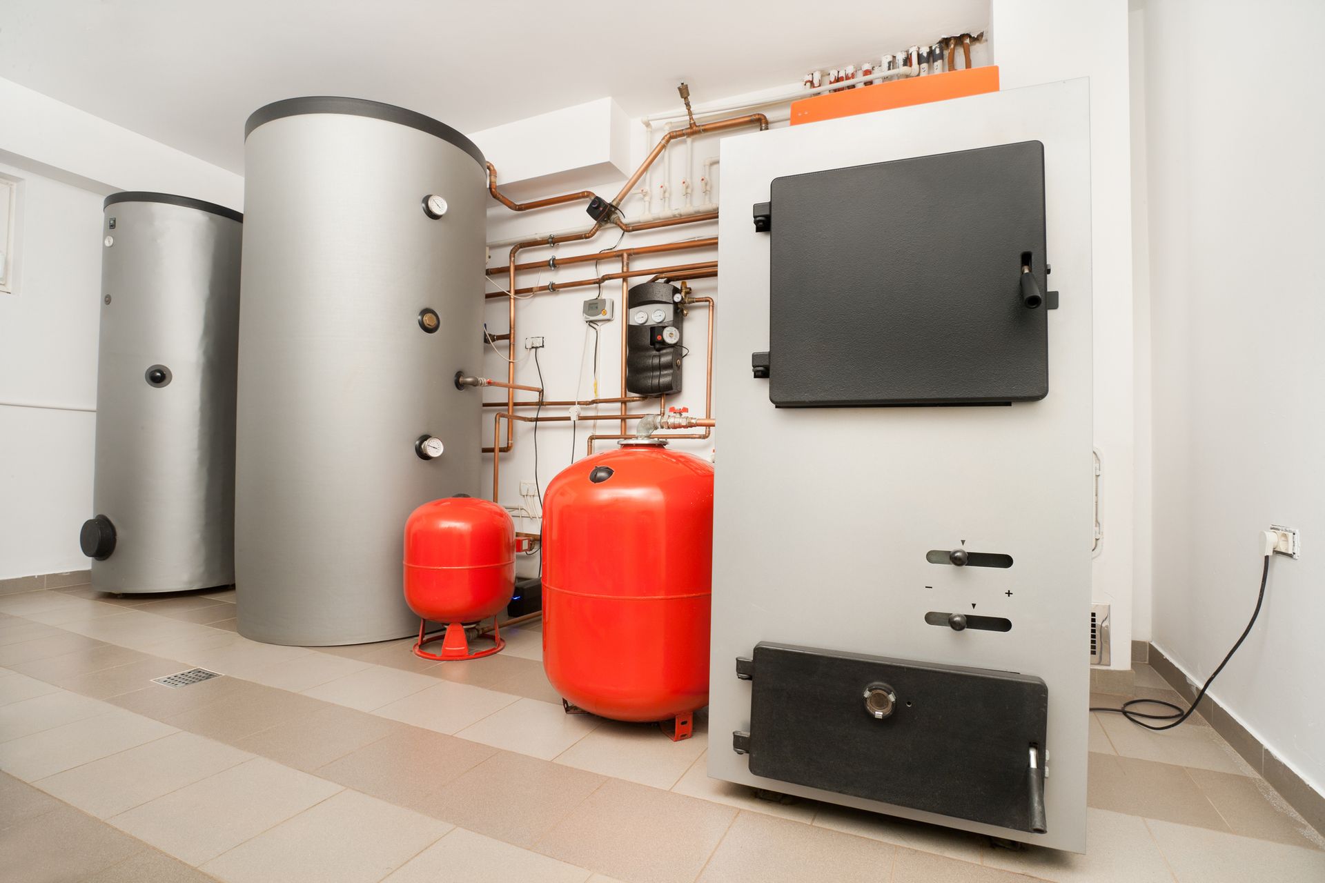 A room with a lot of boilers and tanks in it.