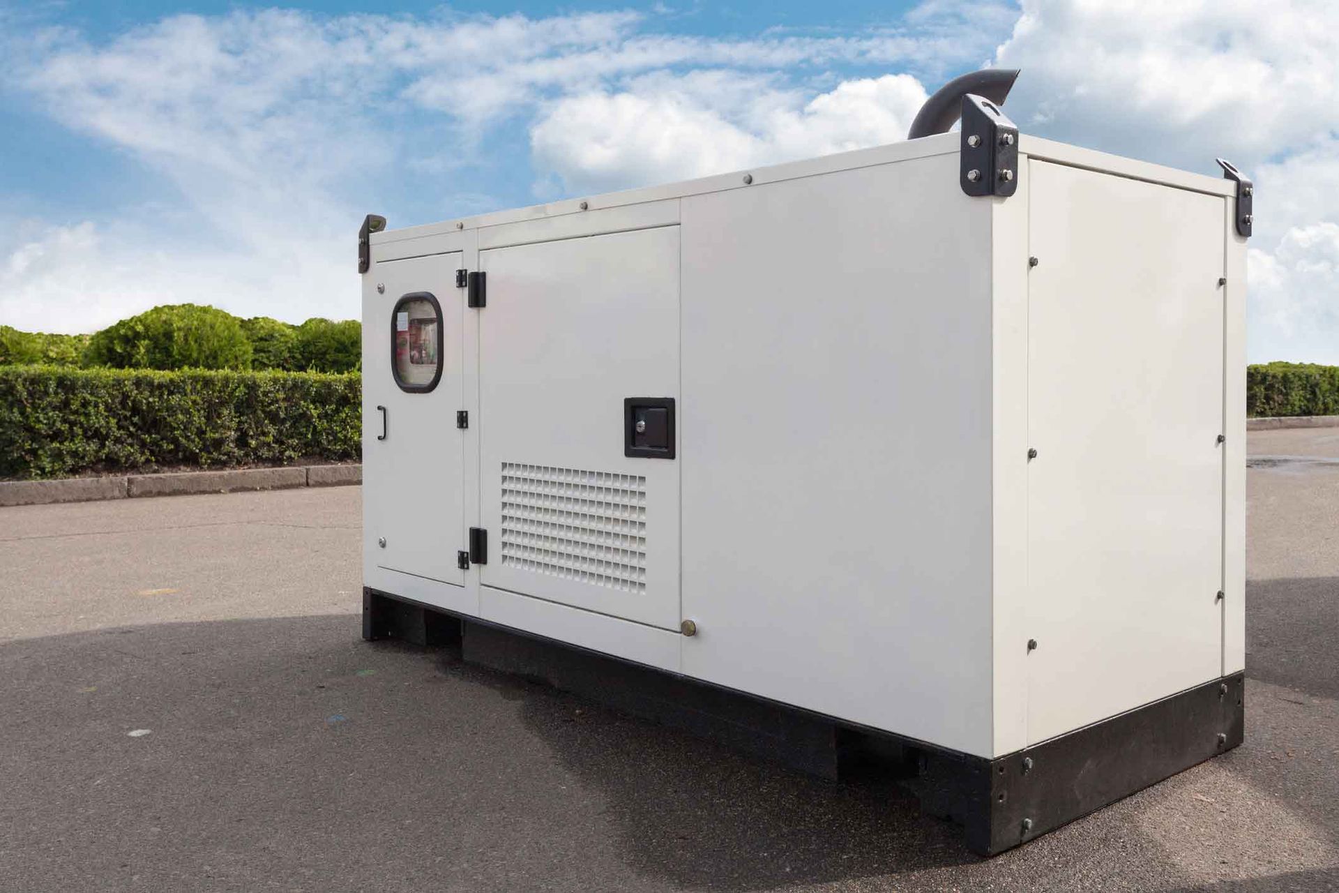 A white generator is parked on the side of the road.