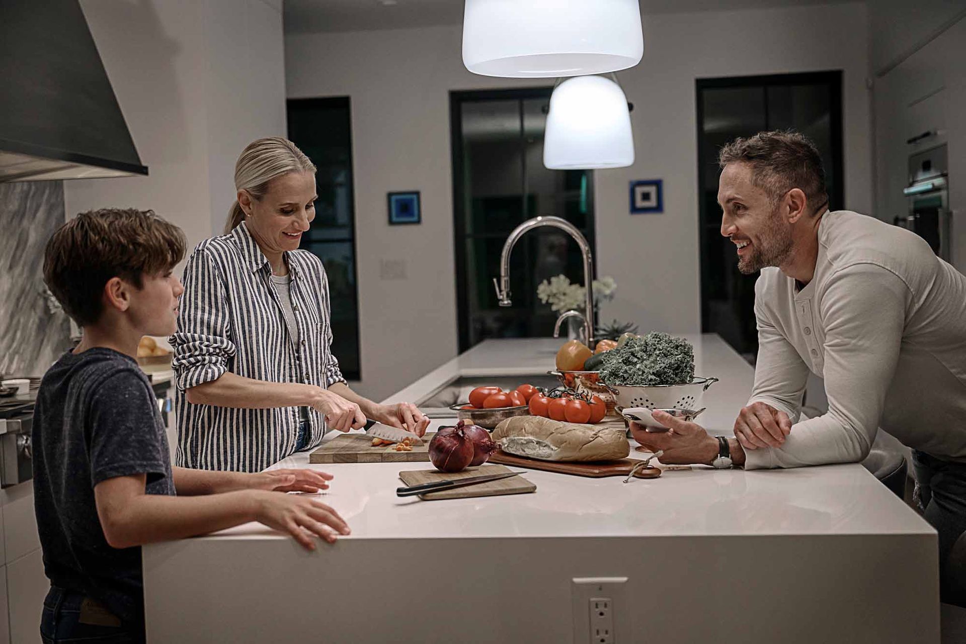 family prepping dinner in well lit kitchen