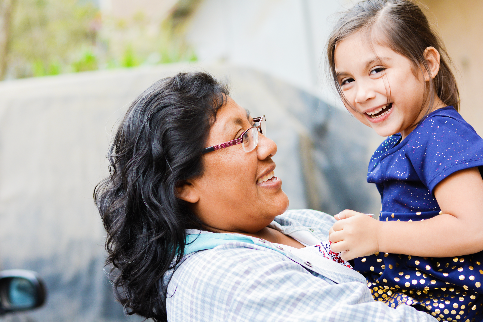 A woman is holding a little girl in her arms.