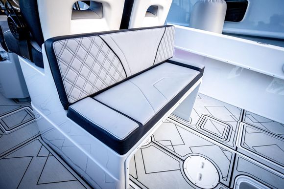 Close-up of a modern interior featuring warm, light-brown wood flooring and white wall structures.