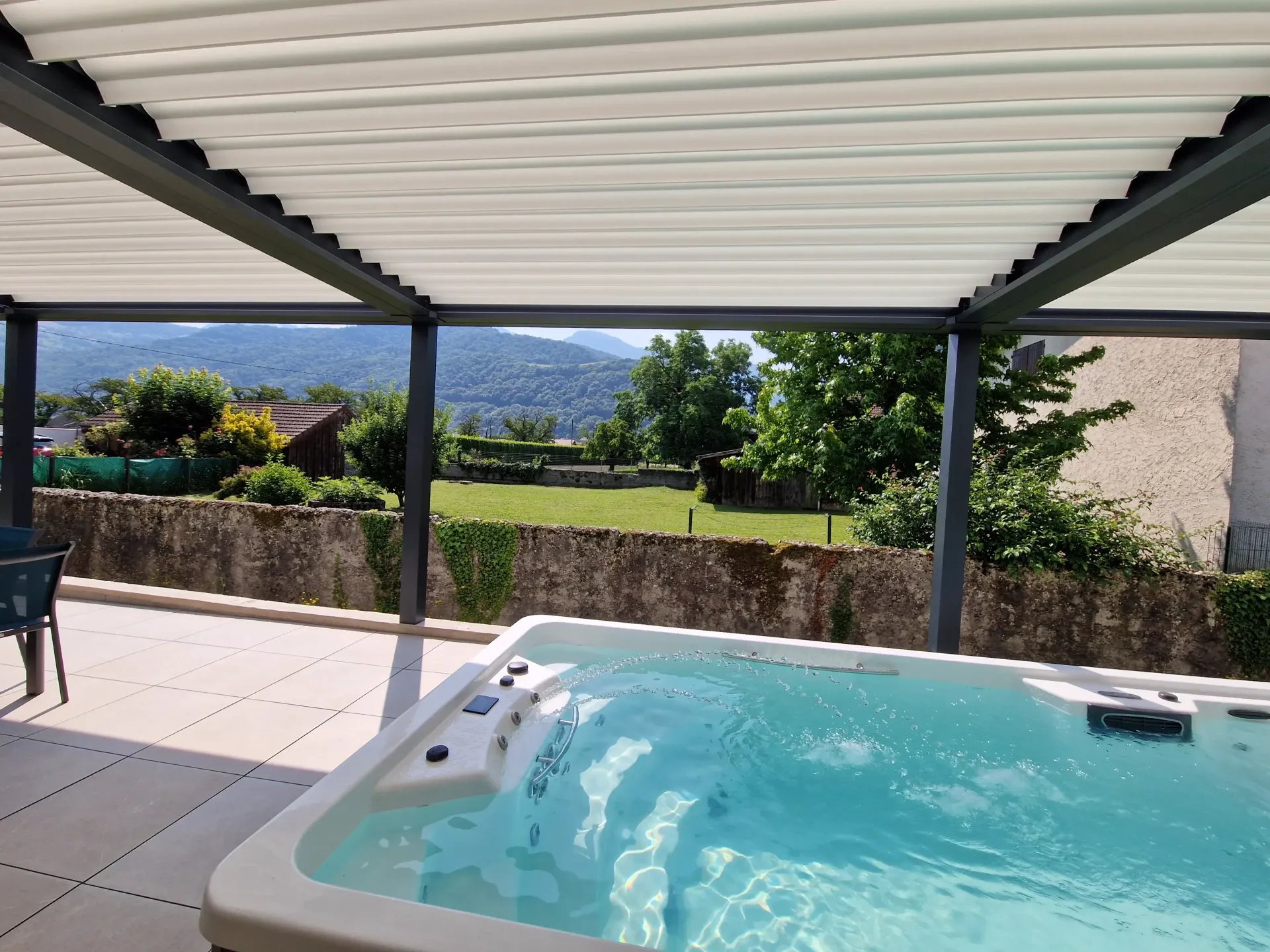 un bain à remous est assis sous une pergola sur une terrasse .