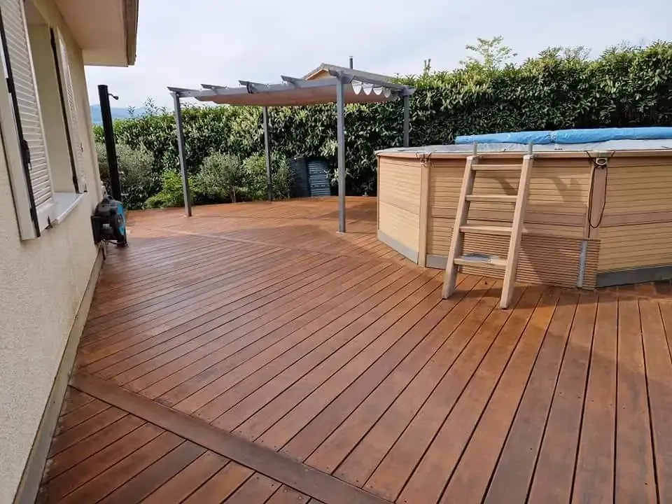 une terrasse en bois avec une échelle à côté d' une piscine