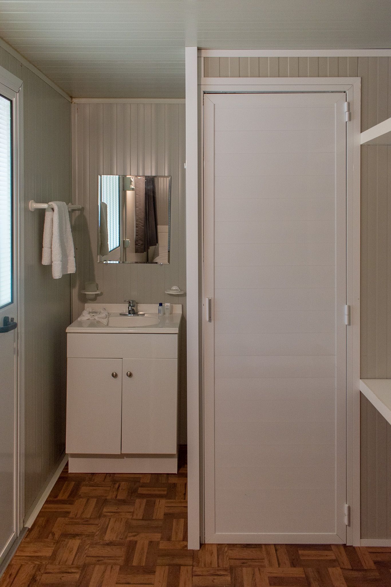 Un baño con lavabo, espejo y puerta.