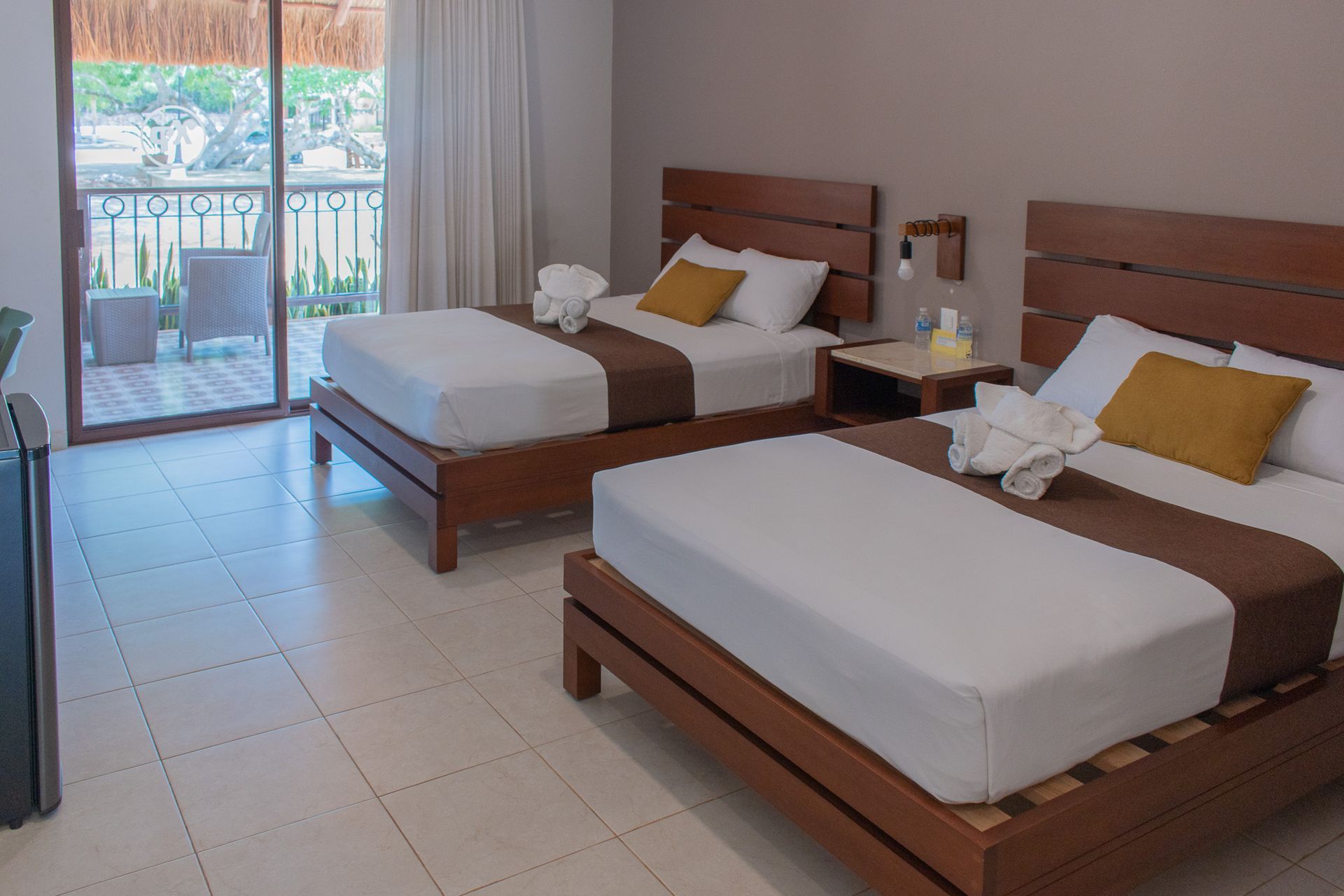 Una habitación de hotel con dos camas y balcón.