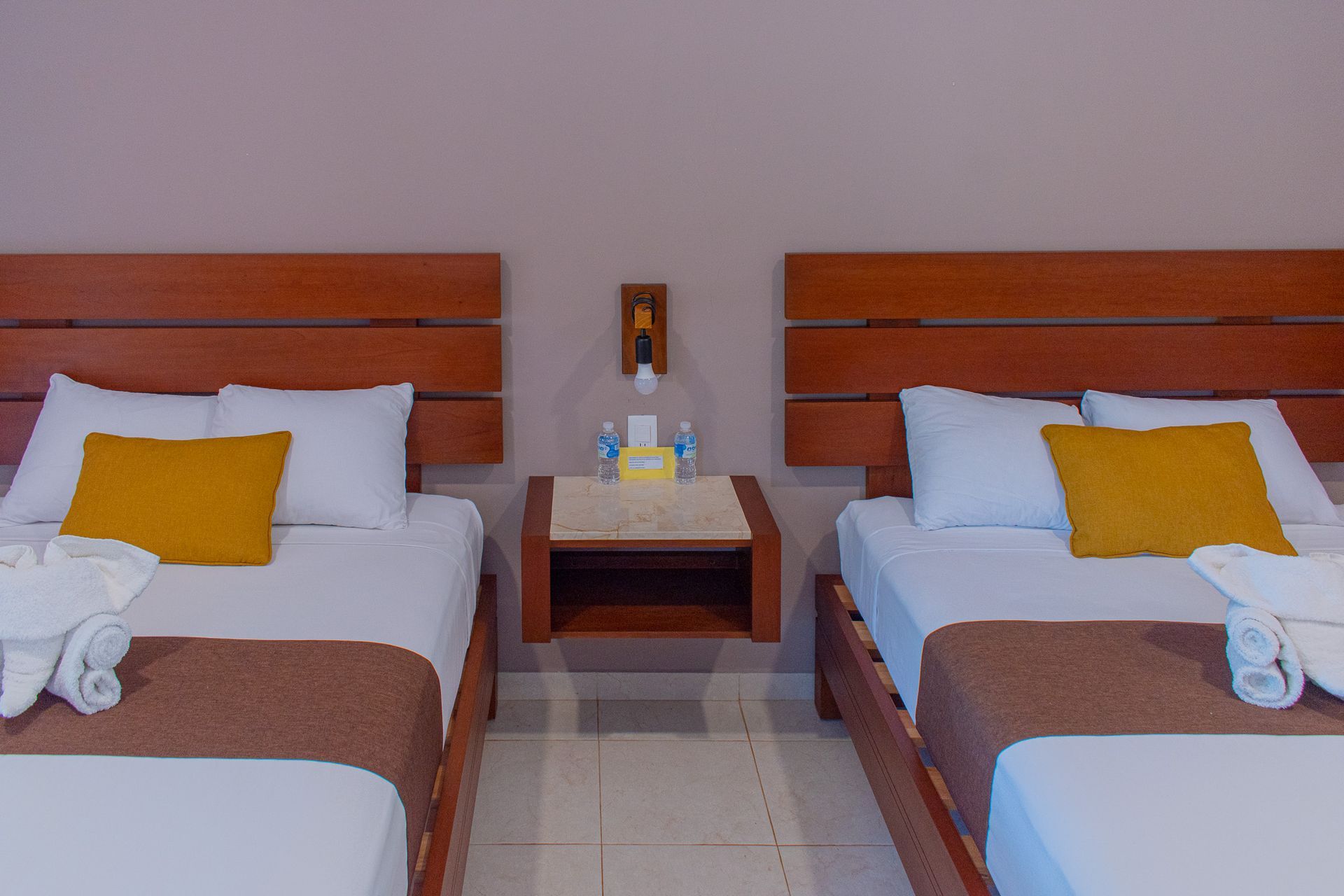 Una habitación de hotel con dos camas y dos mesitas de noche.