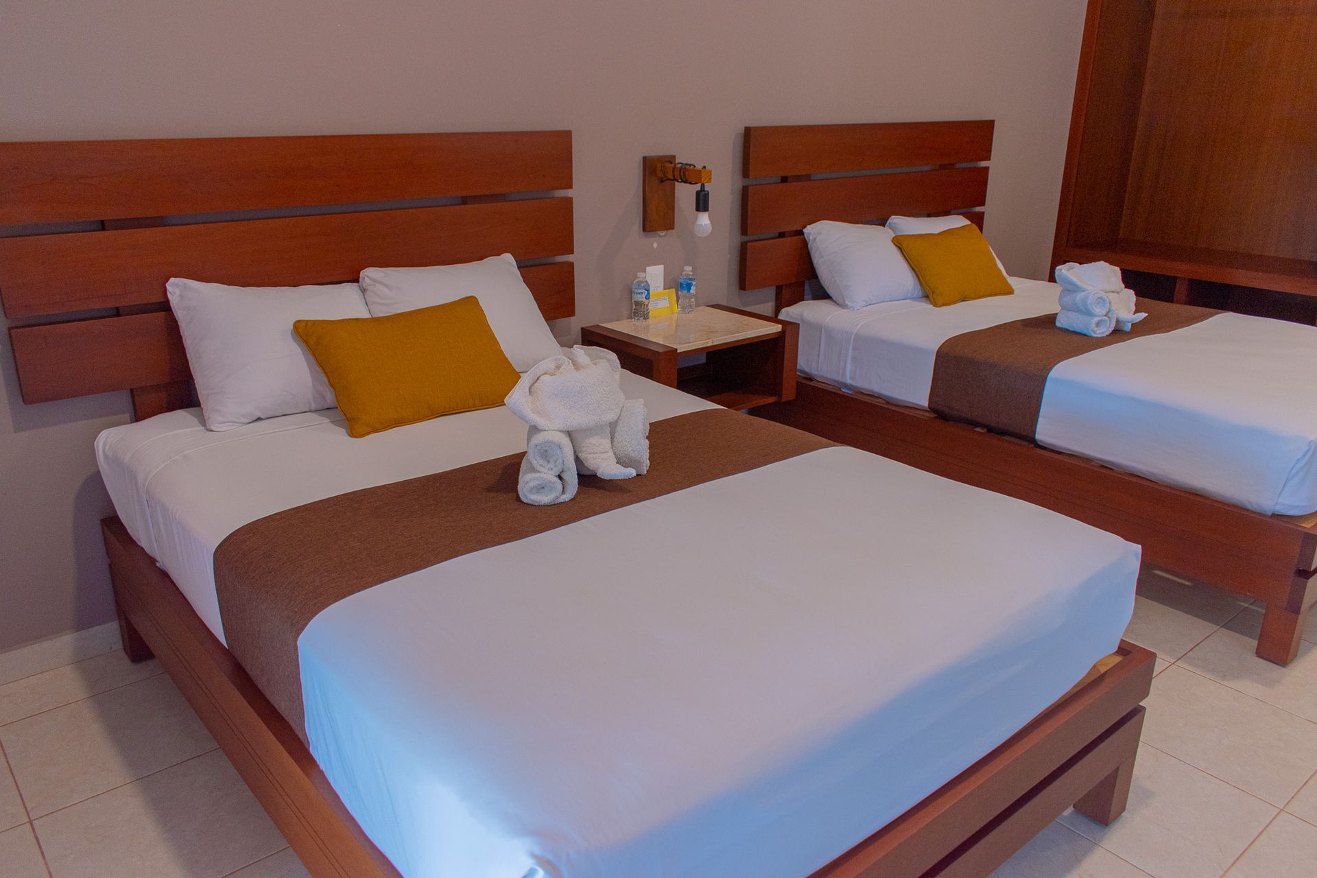 Una habitación de hotel con dos camas y una mesita de noche.