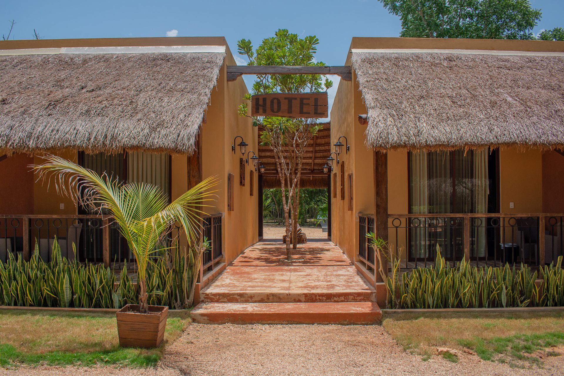 Un hotel con techos de paja y palmeras en frente.