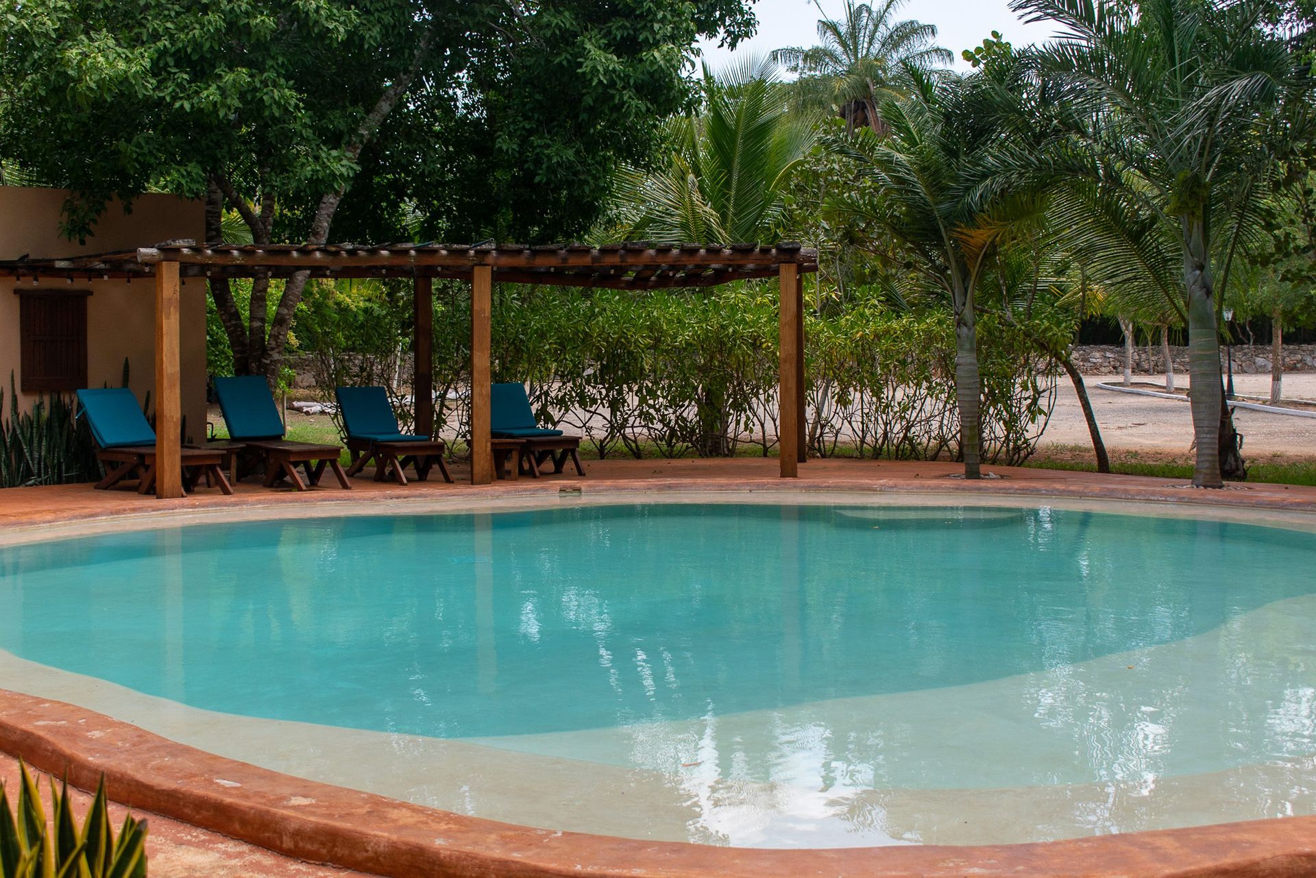 Una gran piscina rodeada de sillas y árboles.