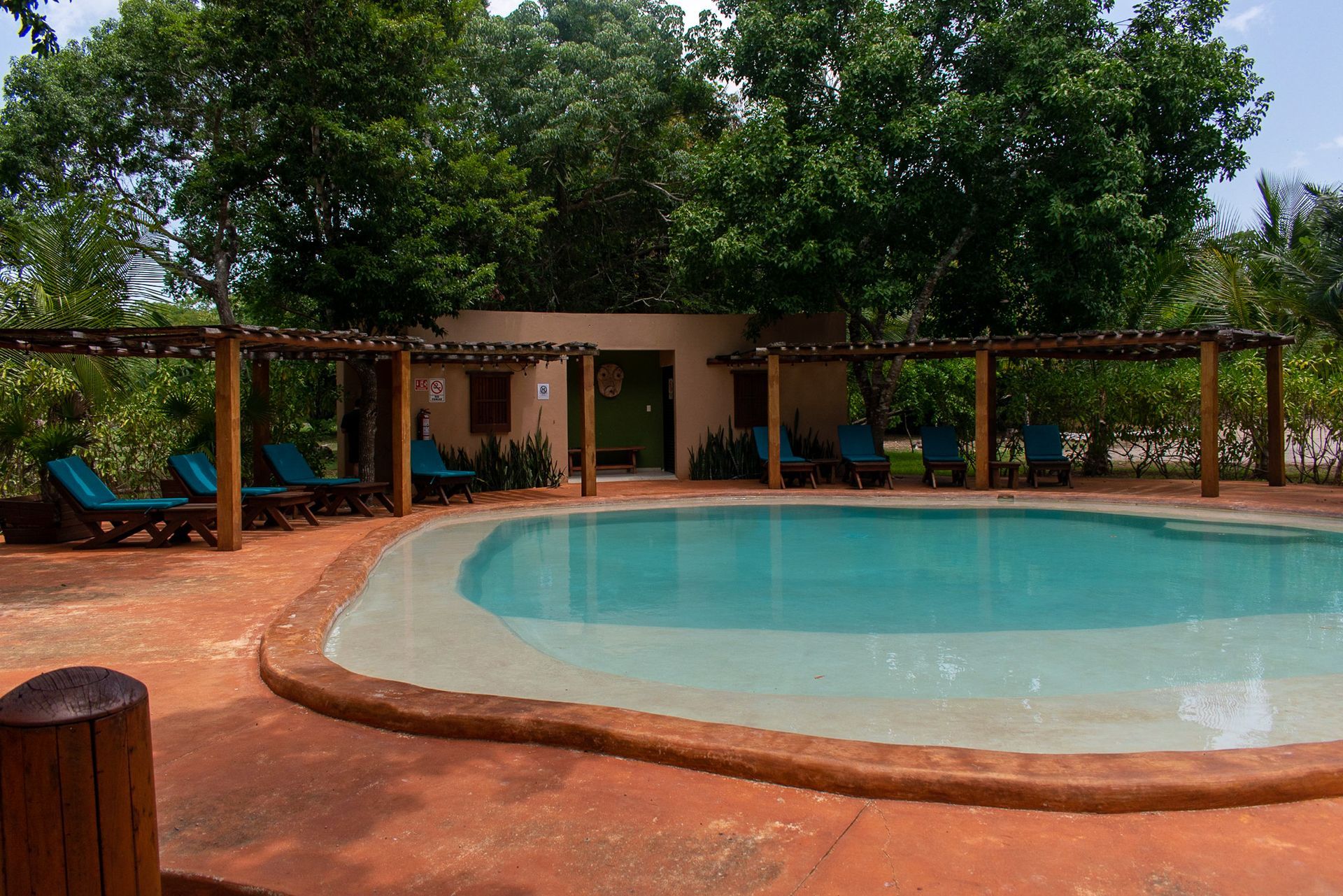 Una gran piscina rodeada de sillas y árboles.