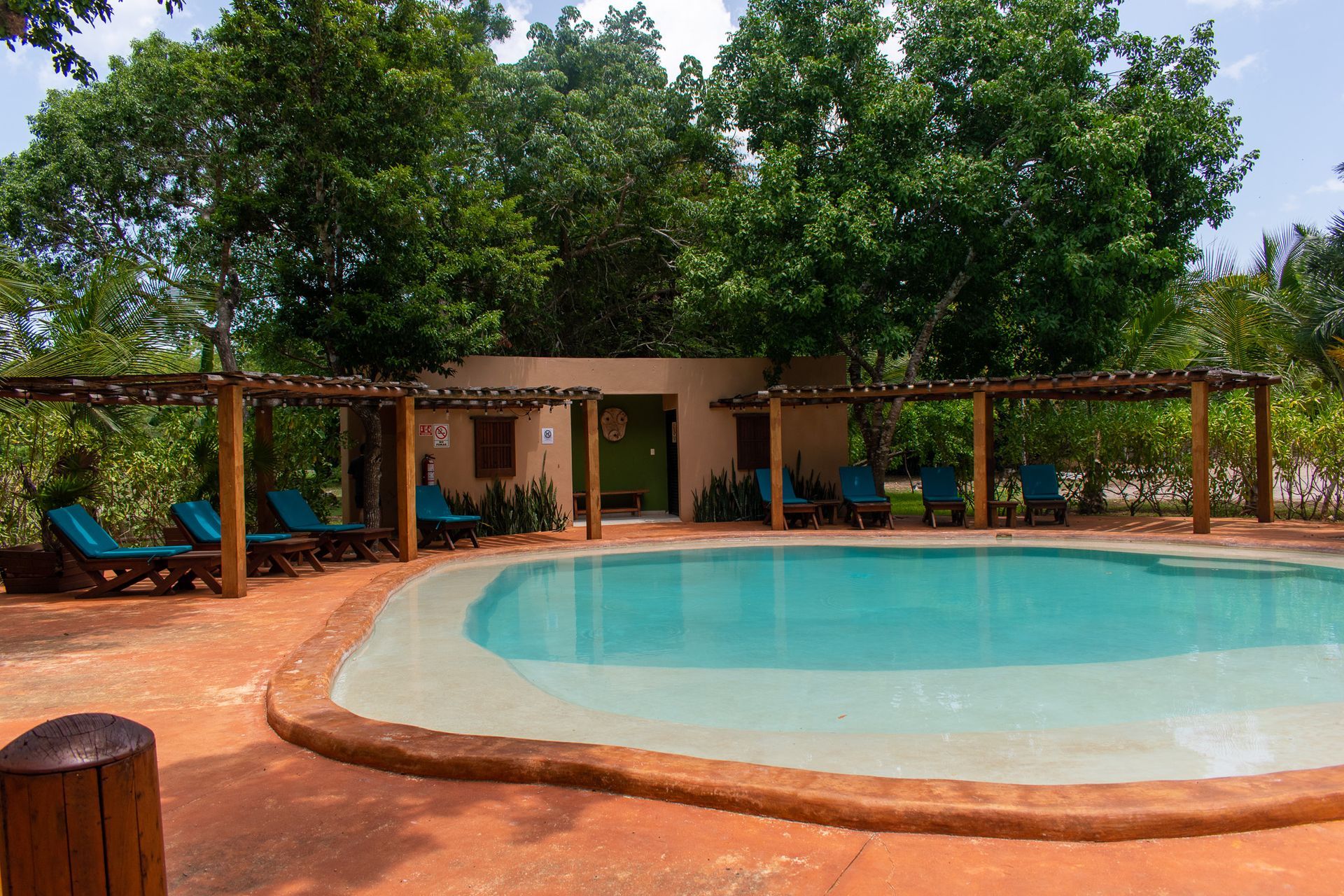 Una gran piscina rodeada de sillas y árboles.