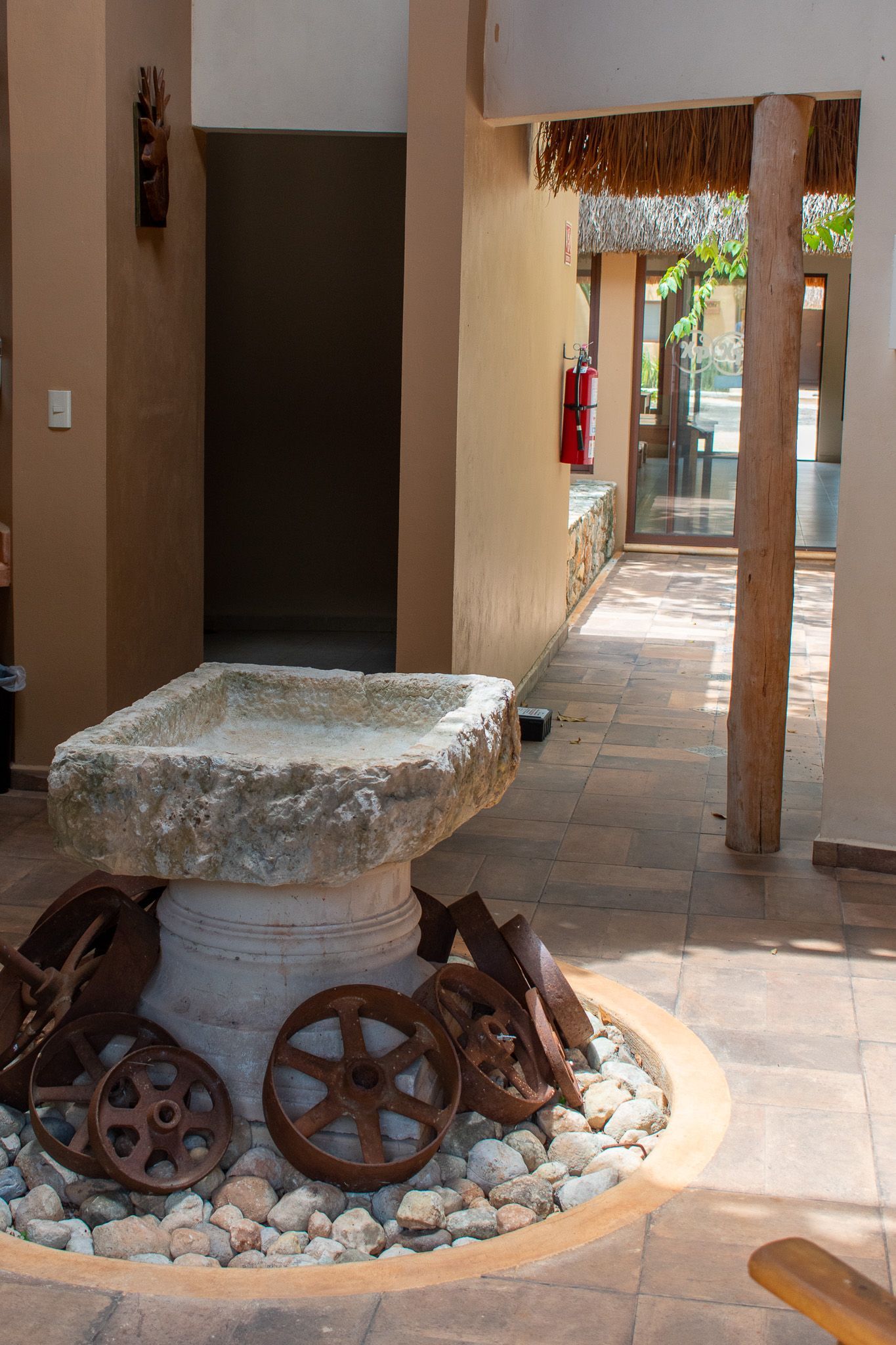 Una fuente de piedra rodeada de rocas y ruedas en un patio.