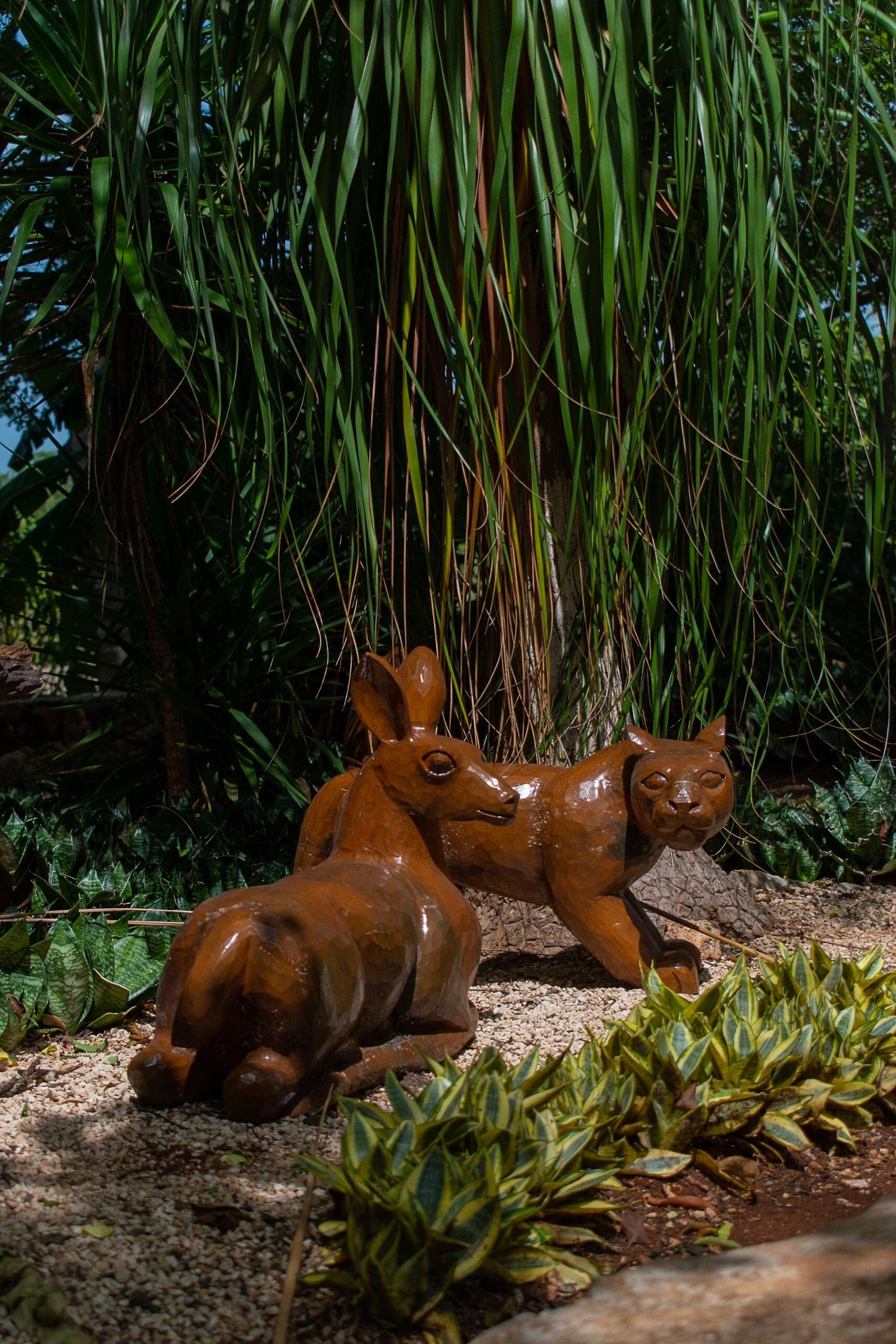Un par de estatuas sentados uno al lado del otro en un jardín.
