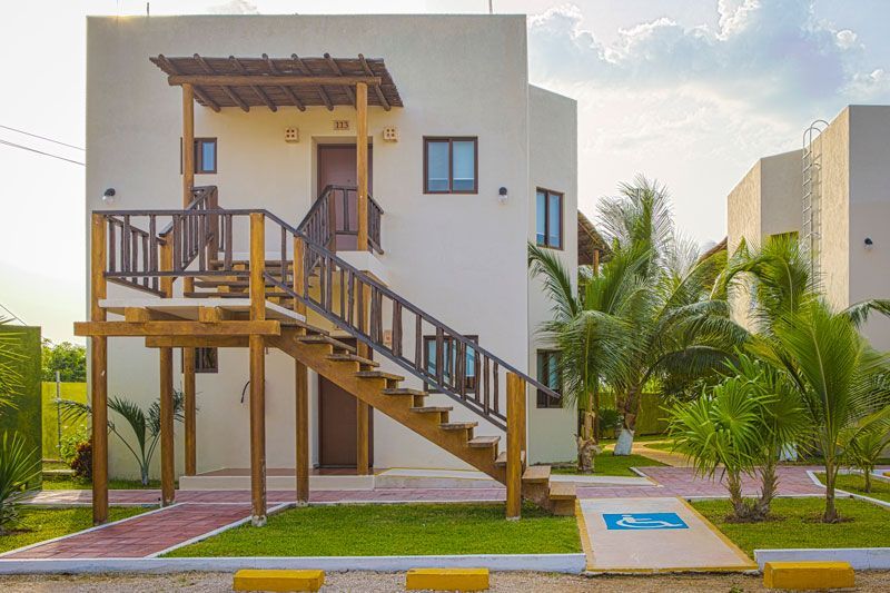 Una casa blanca con escaleras de madera que conducen al segundo piso.