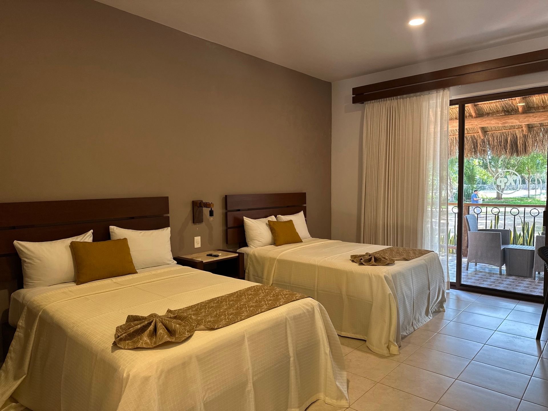 Una habitación de hotel con dos camas y balcón.