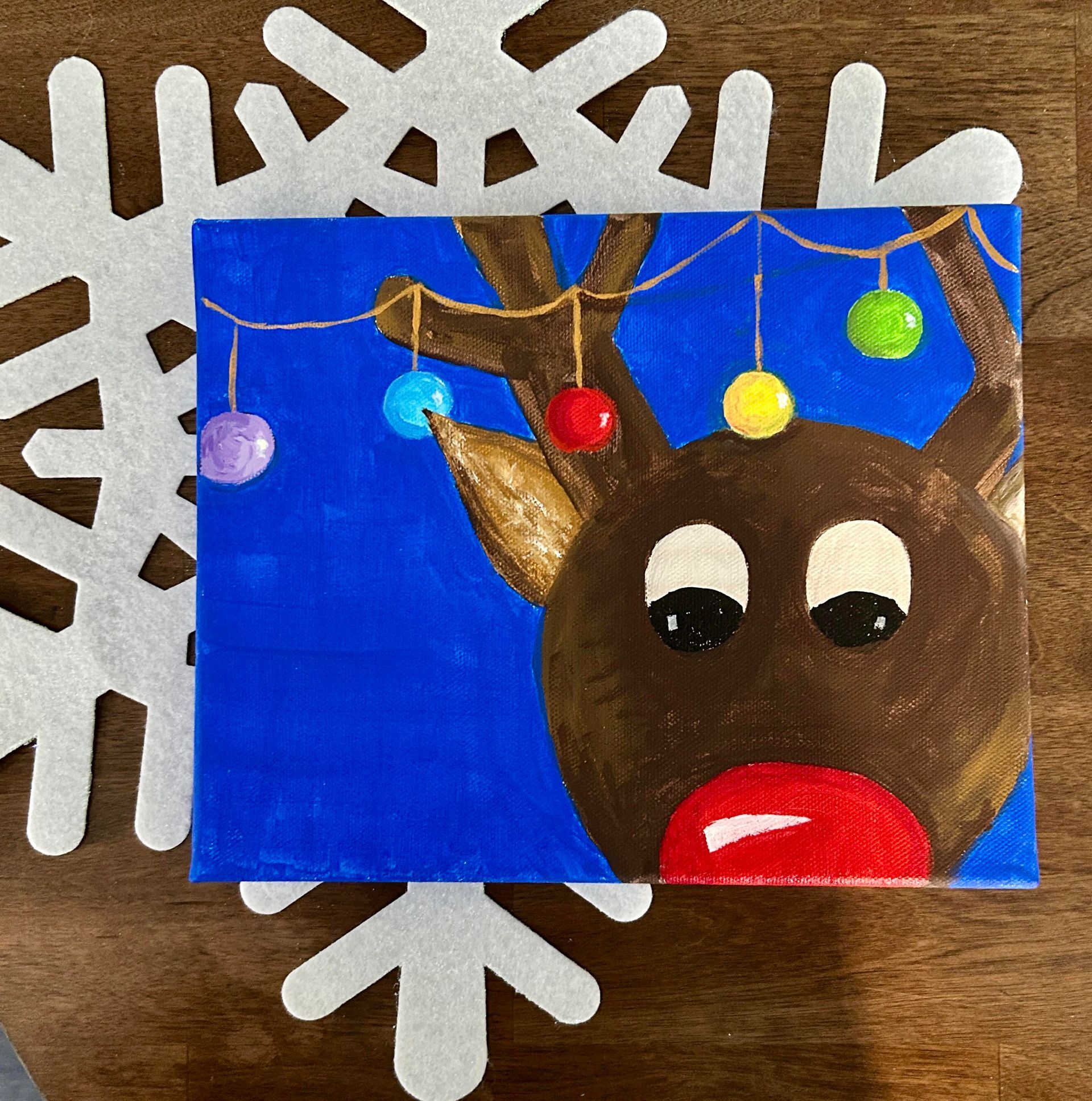 A painting of a reindeer with christmas lights hanging from its antlers