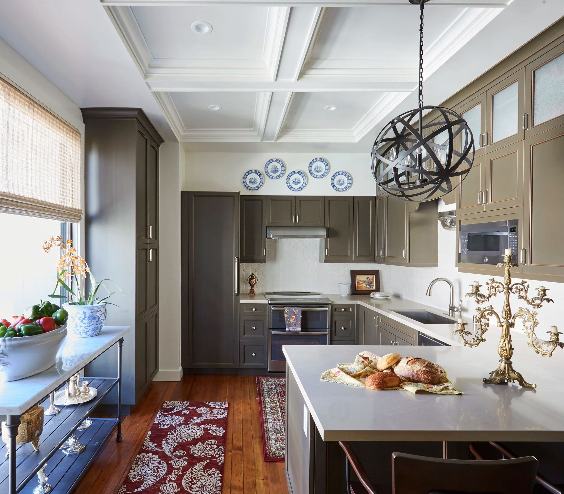 Kitchen with gray cabinets, wood floors, island, and decorative ceiling.