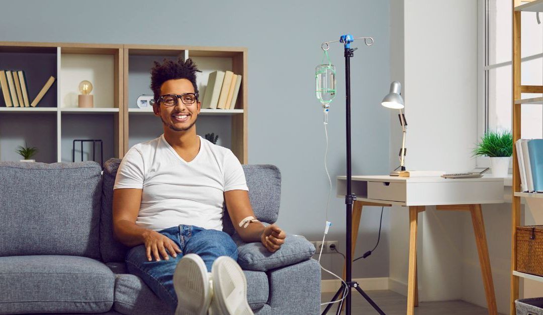 a man is sitting on a couch with an iv in his arm
