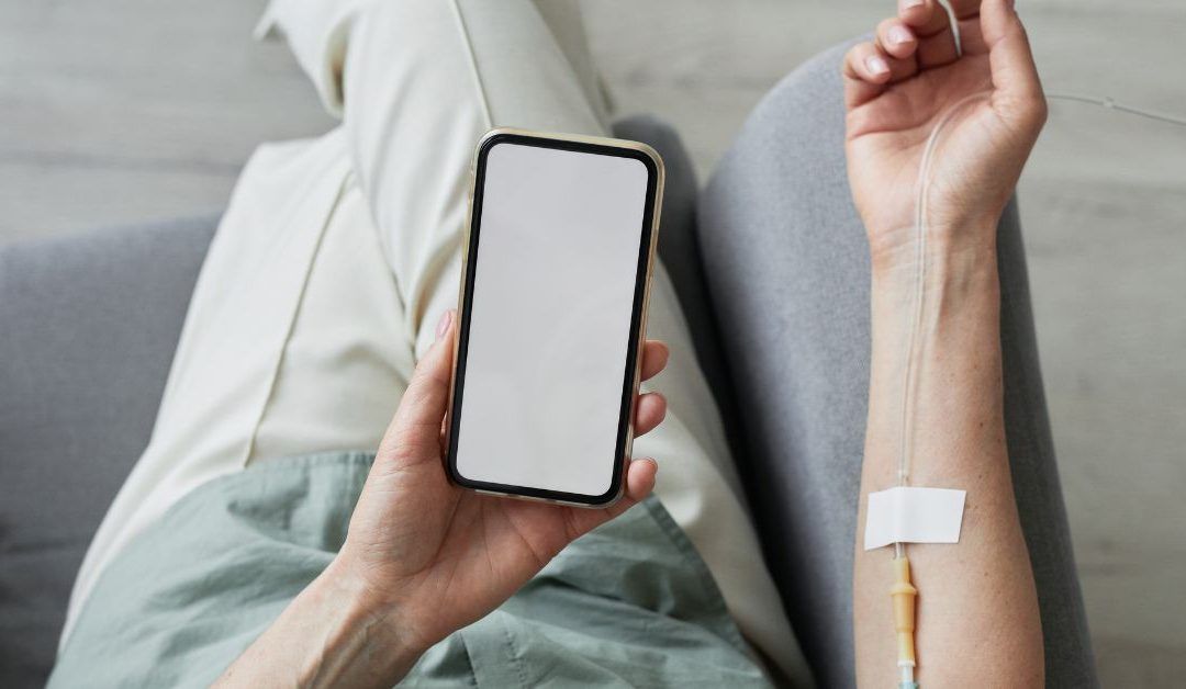 a person with an iv in their arm is holding a cell phone