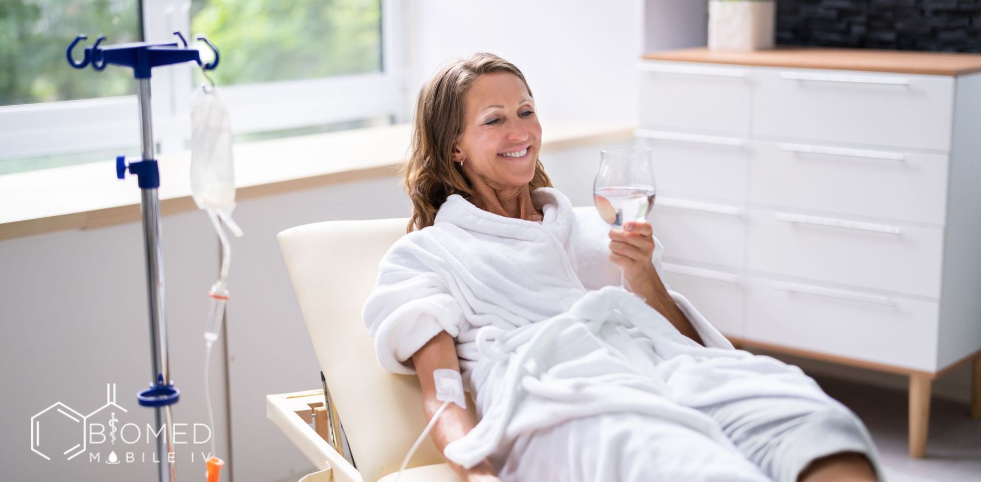 Woman drinking water while getting iv infusion