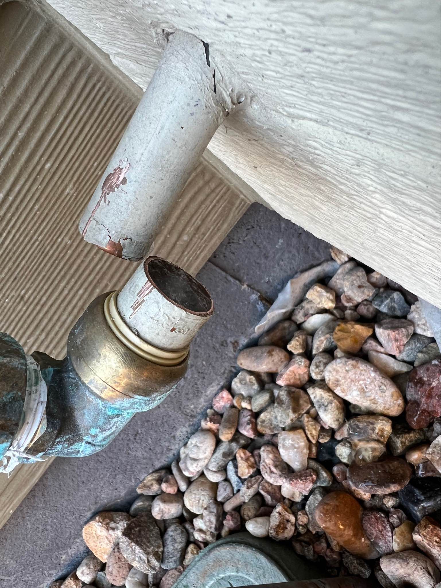 A pipe is sitting on top of a pile of rocks.