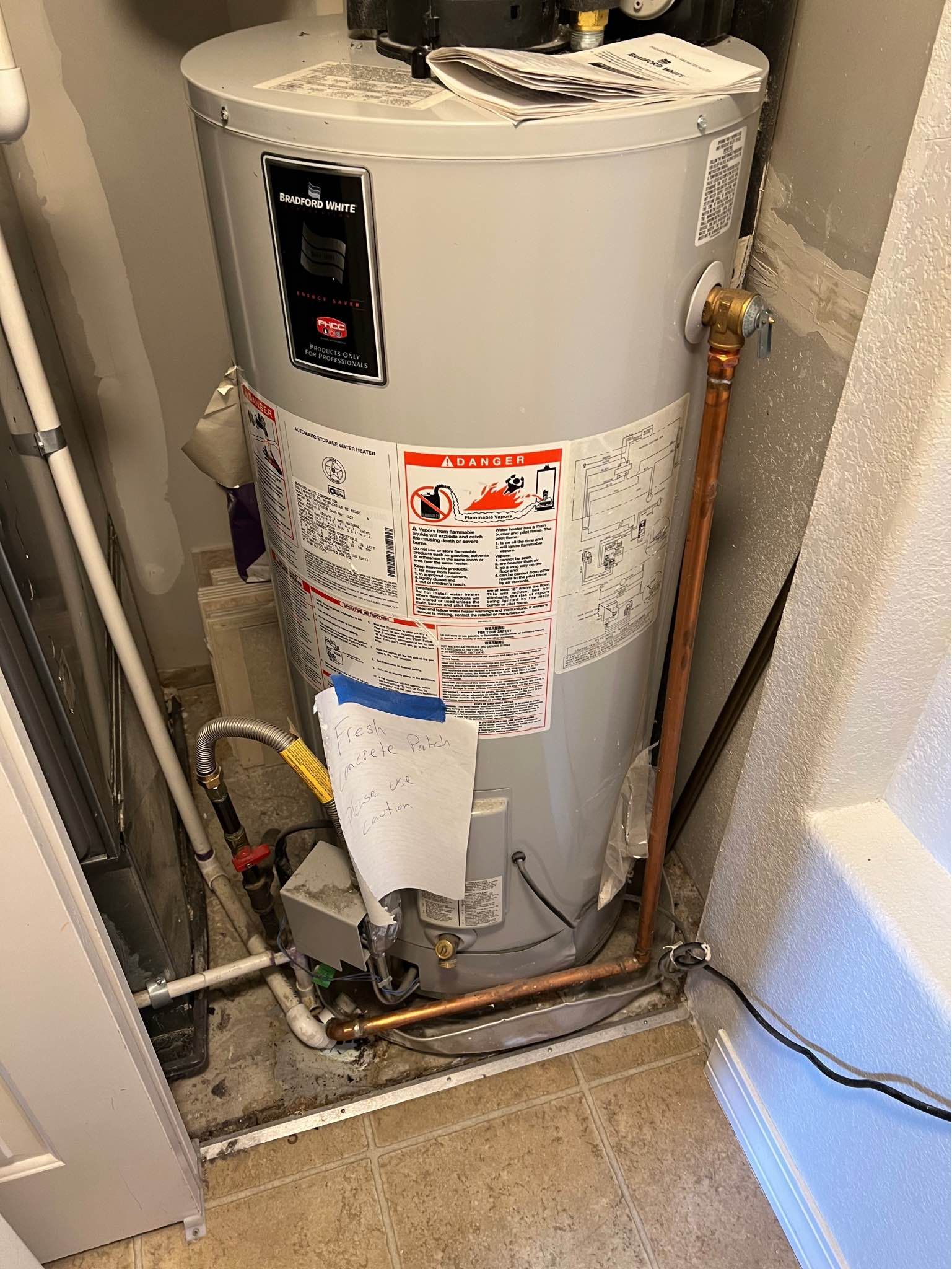 A water heater is sitting on the floor in a room.