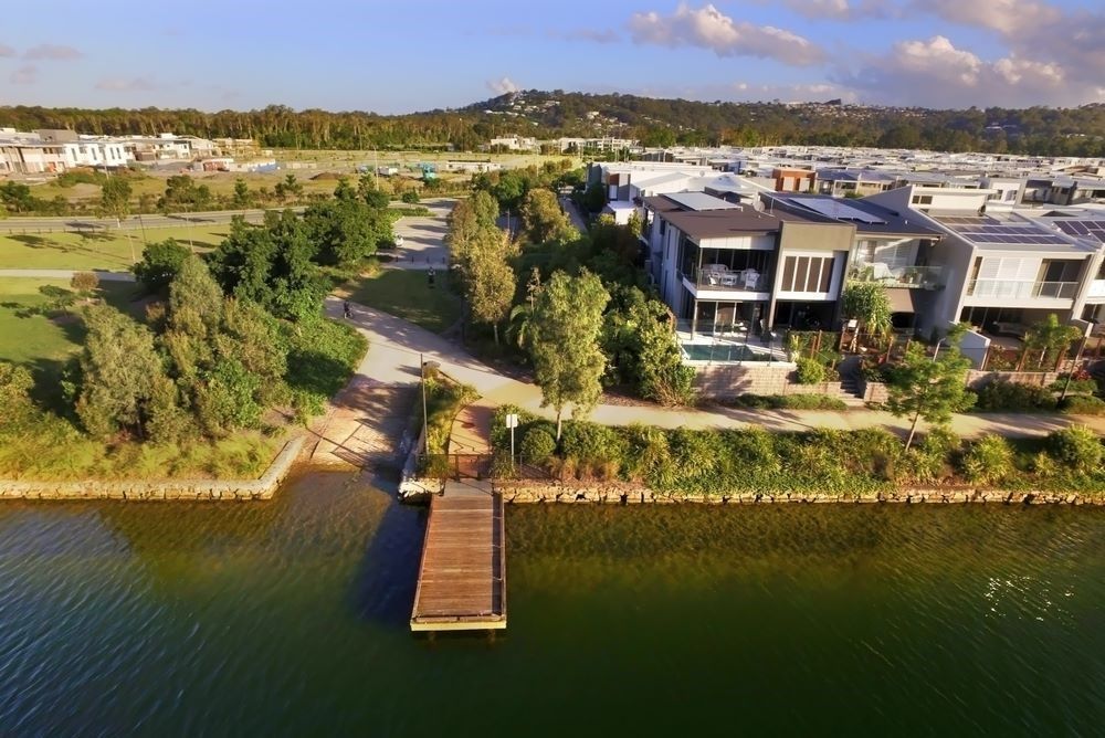 An Aerial View of a House Next to a Body of Water — Core Pest Management in Maroochydore, QLD