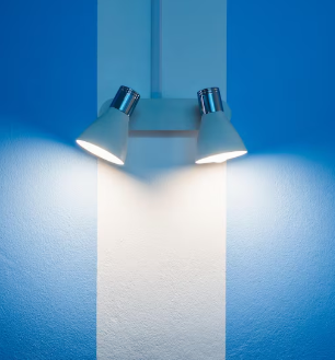 Un par de focos blancos iluminan una sección de pared blanca con rayas azules.