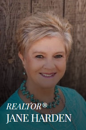 Jane Harden, realtor, smiling portrait with teal blouse and turquoise necklace.