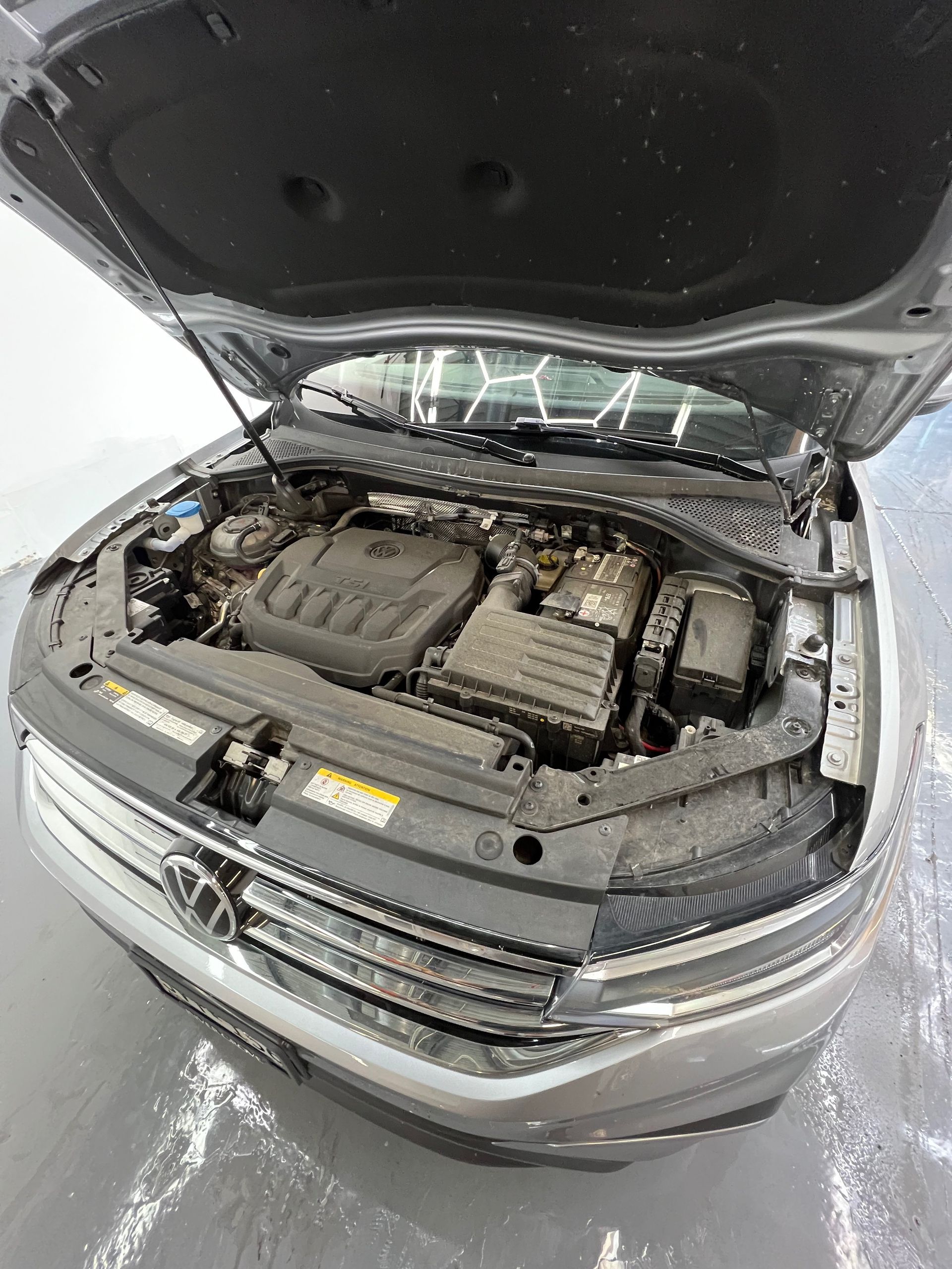 The engine of a volkswagen tiguan is shown with the hood open.