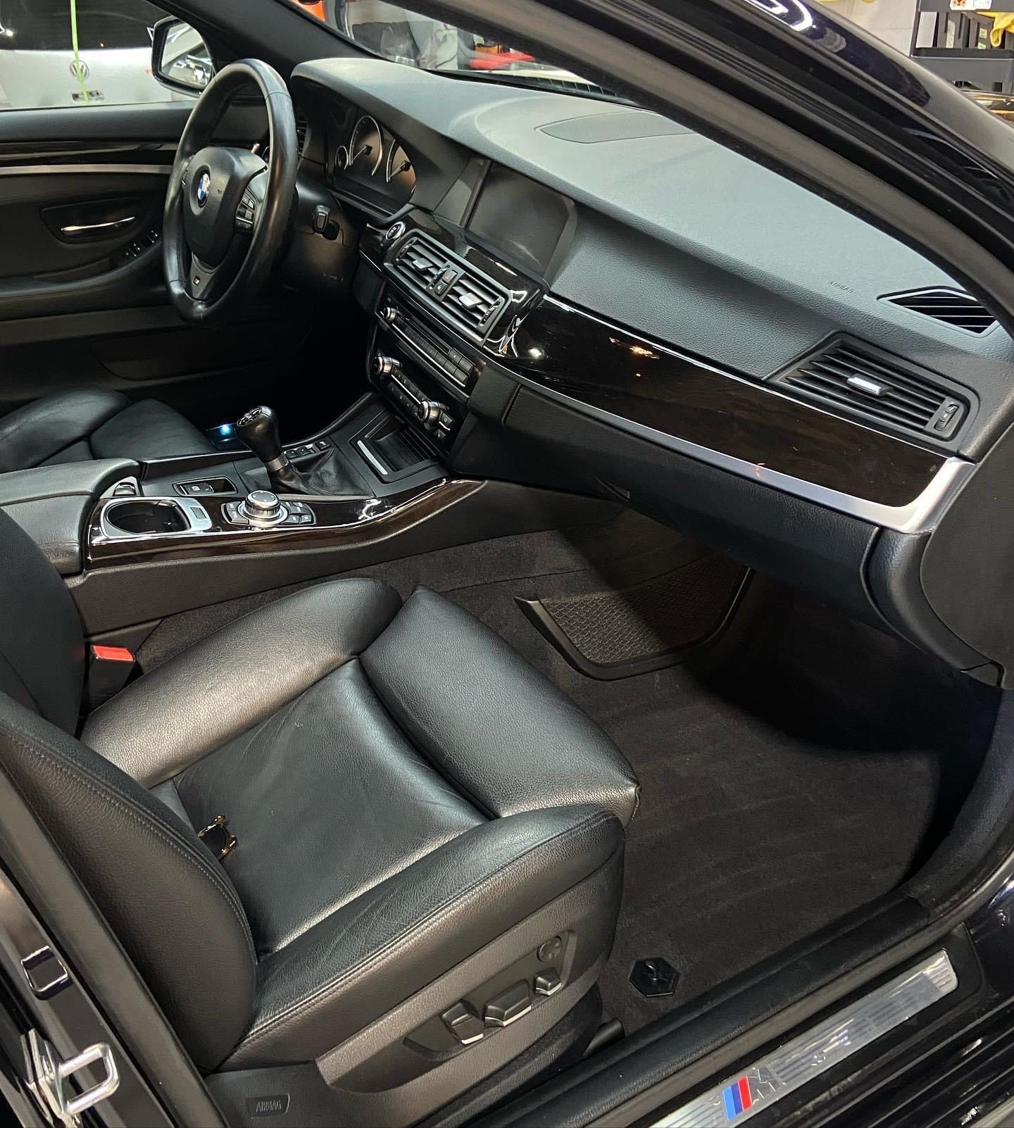 The interior of a black car with the door open