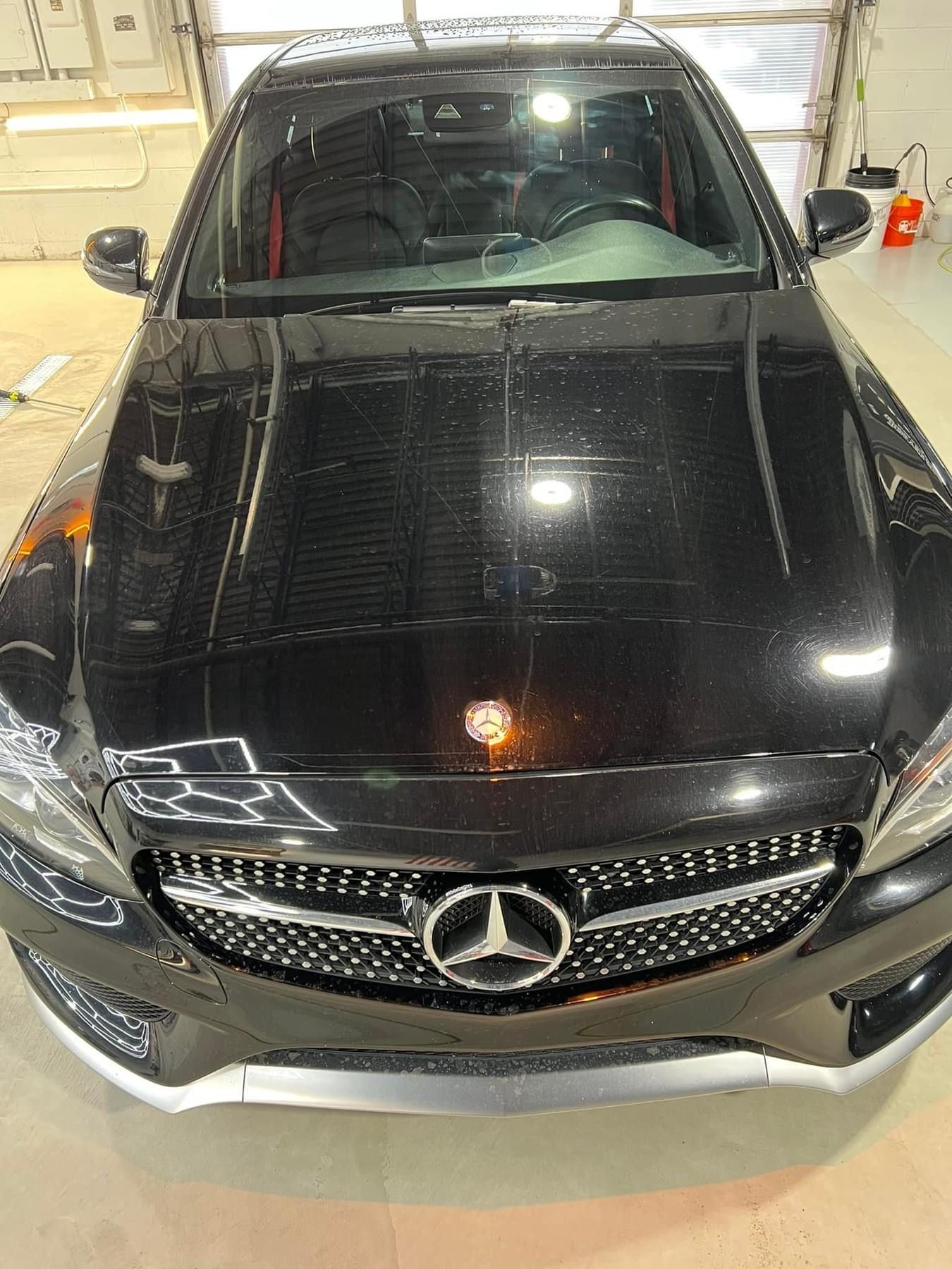 A black mercedes benz is parked in a garage.