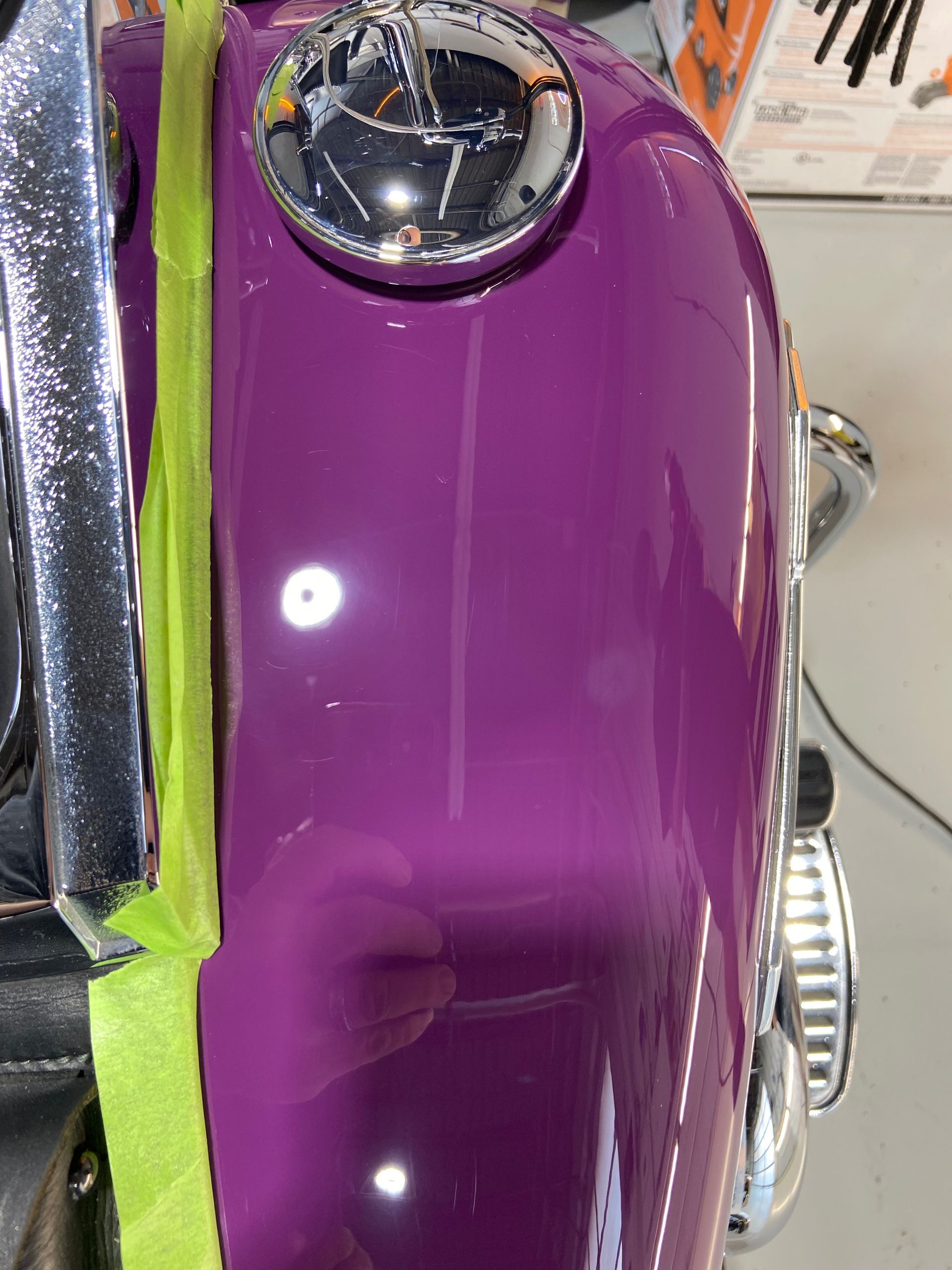 A close up of a purple motorcycle with green tape on it.