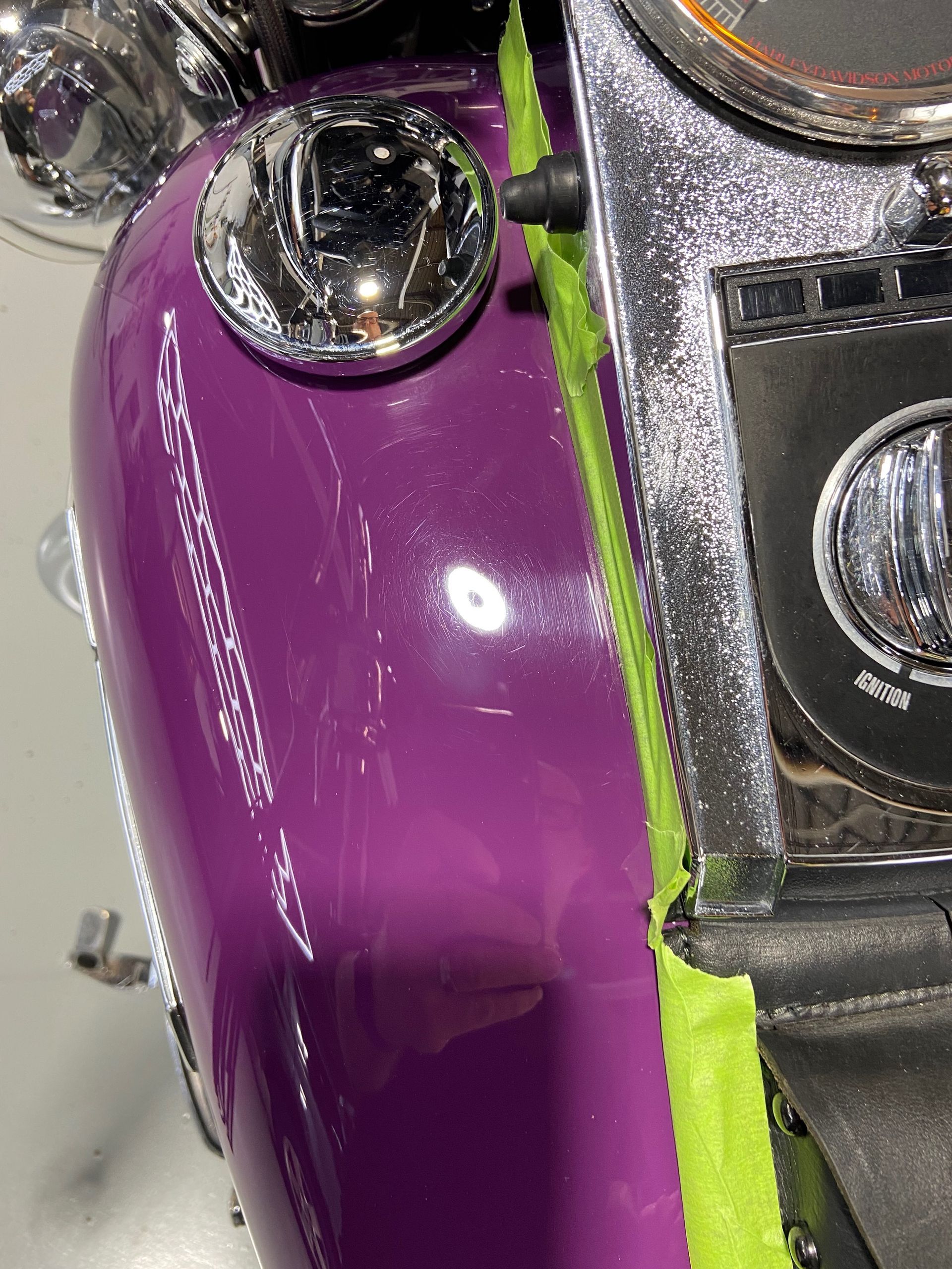 A close up of a purple motorcycle with green tape on it.