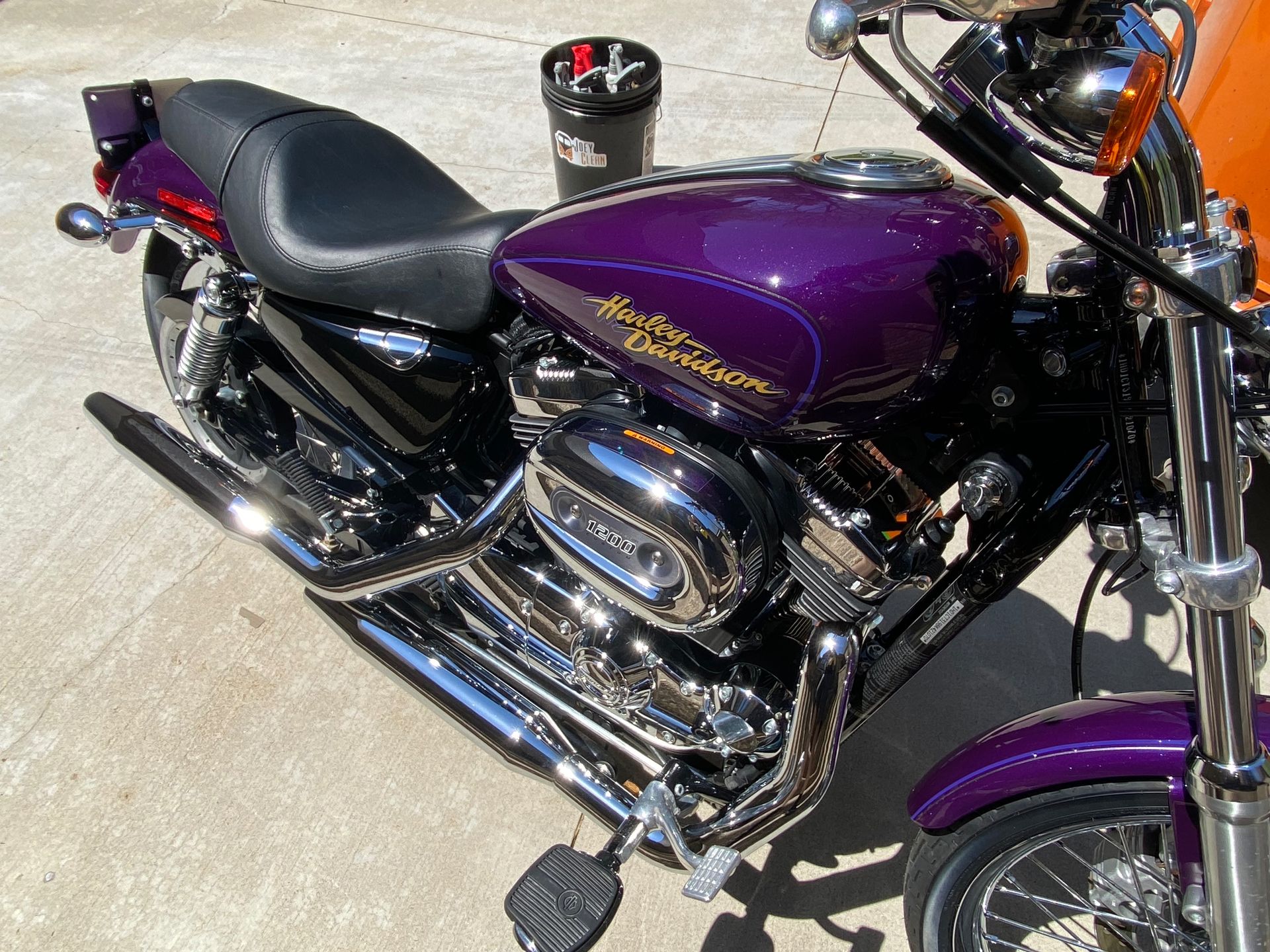 A purple harley davidson motorcycle is parked on the side of the road.