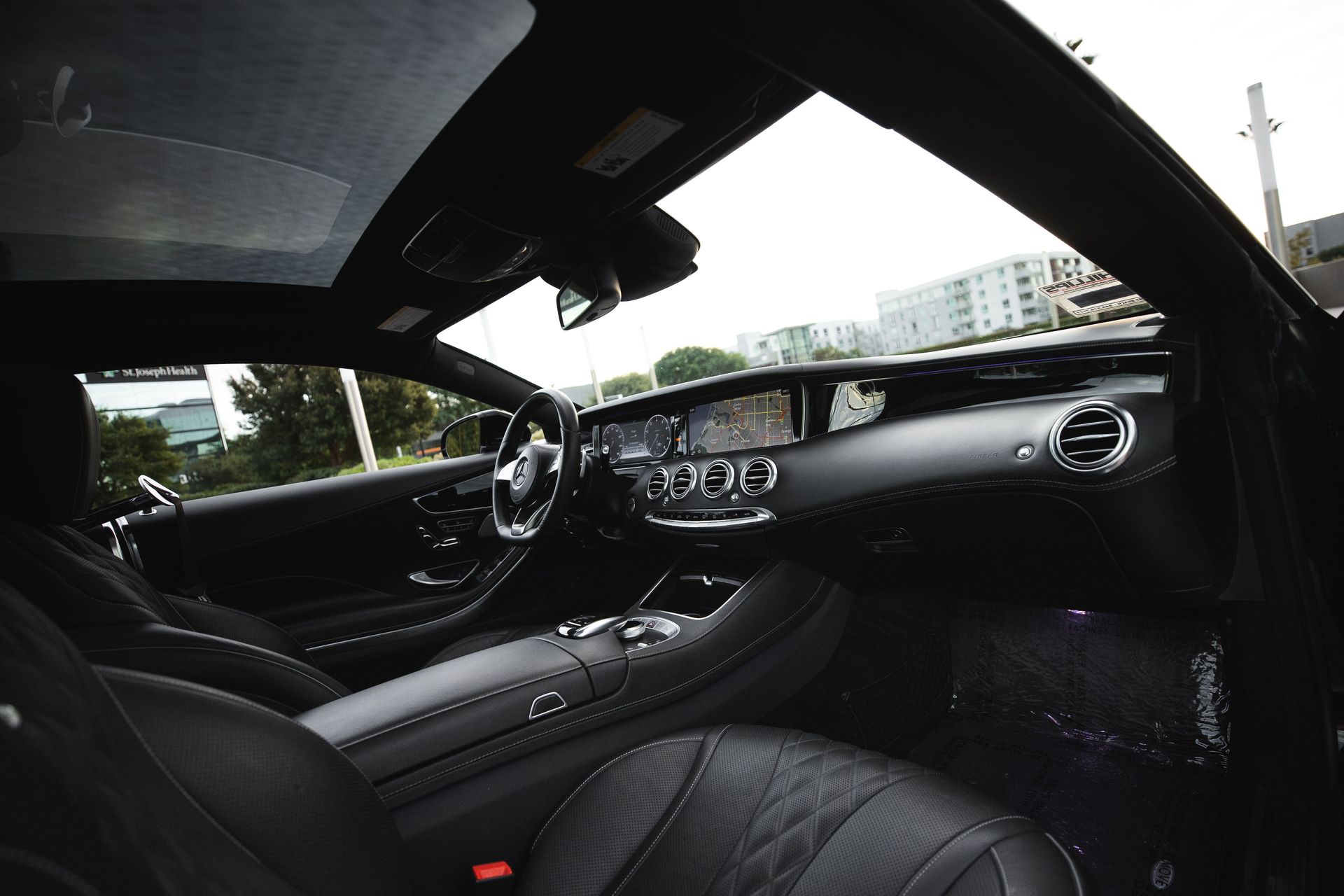 The interior of a black car with a steering wheel and dashboard.