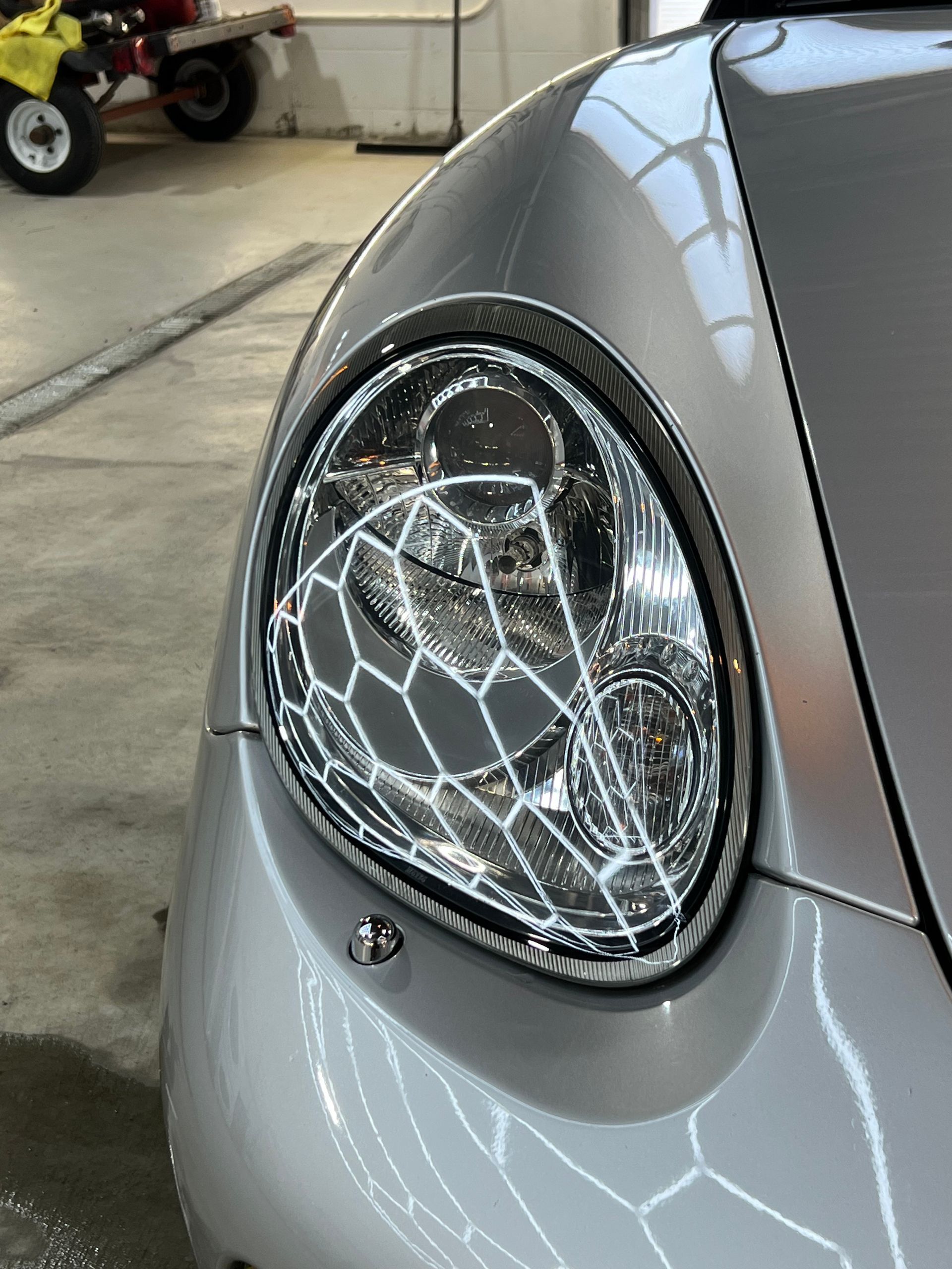 A close up of a car 's headlight in a garage