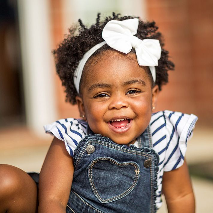 little girl with a bow in her hair smiling