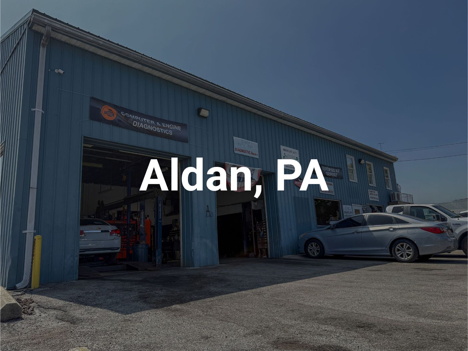 Briarcliffe Auto Service shop  in Glenolden, PA with open bay doors. Several cars are parked outside in a parking lot.