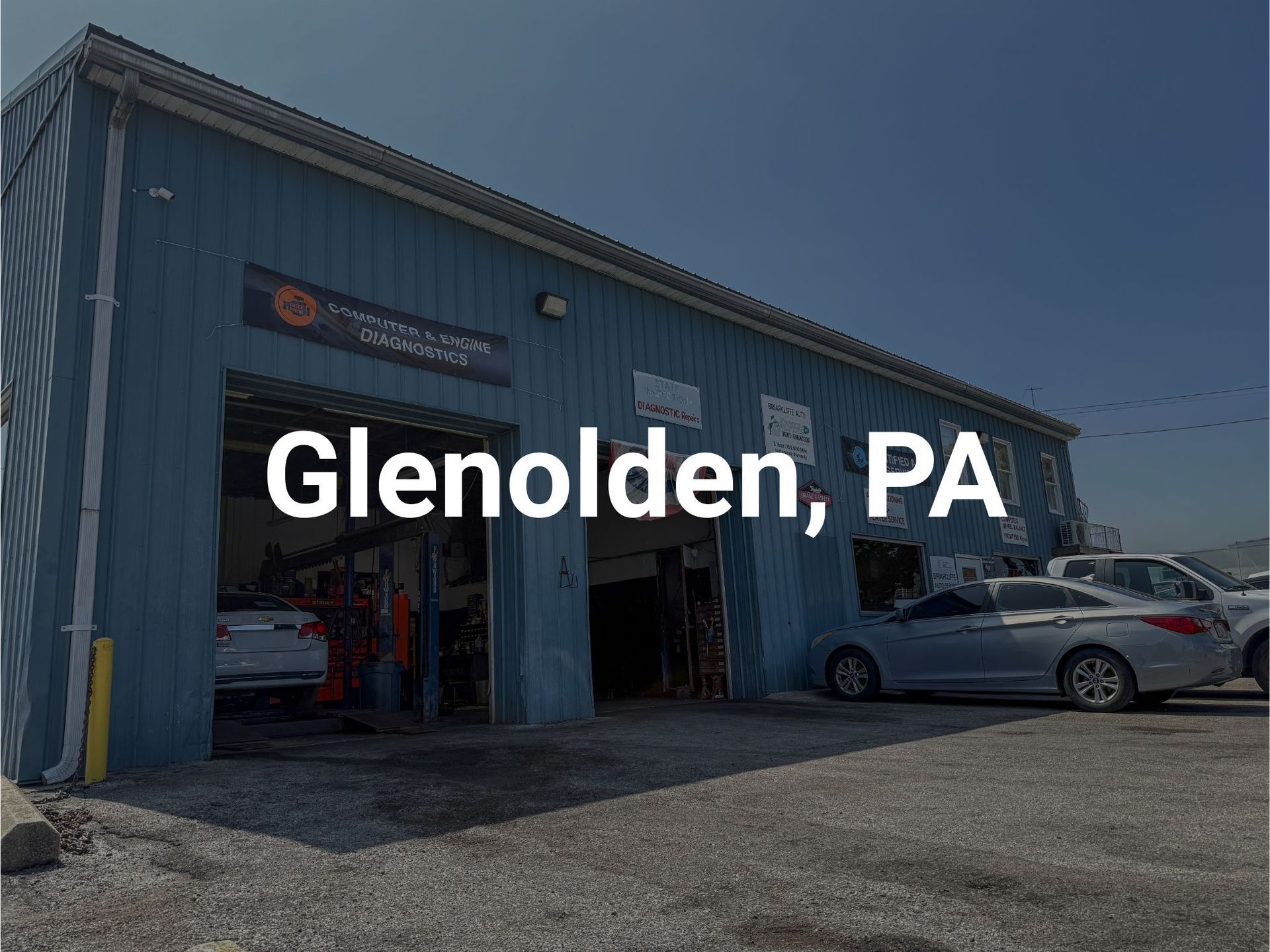 Briarcliffe Auto Service shop in Glenolden, PA with open bay doors. Several cars are parked outside in a parking lot.
