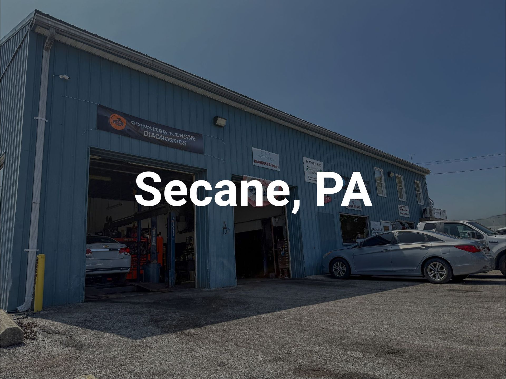 Briarcliffe Auto Service shop in Glenolden, PA with open bay doors. Several cars are parked outside in a parking lot.
