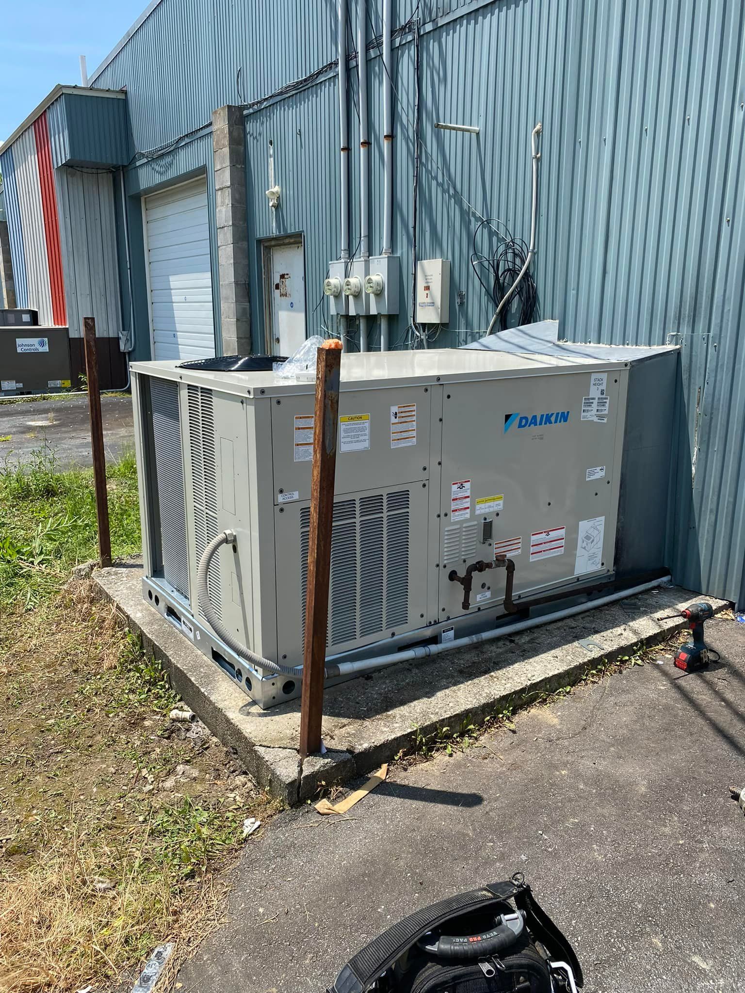 A large air conditioner is sitting on the side of a building.