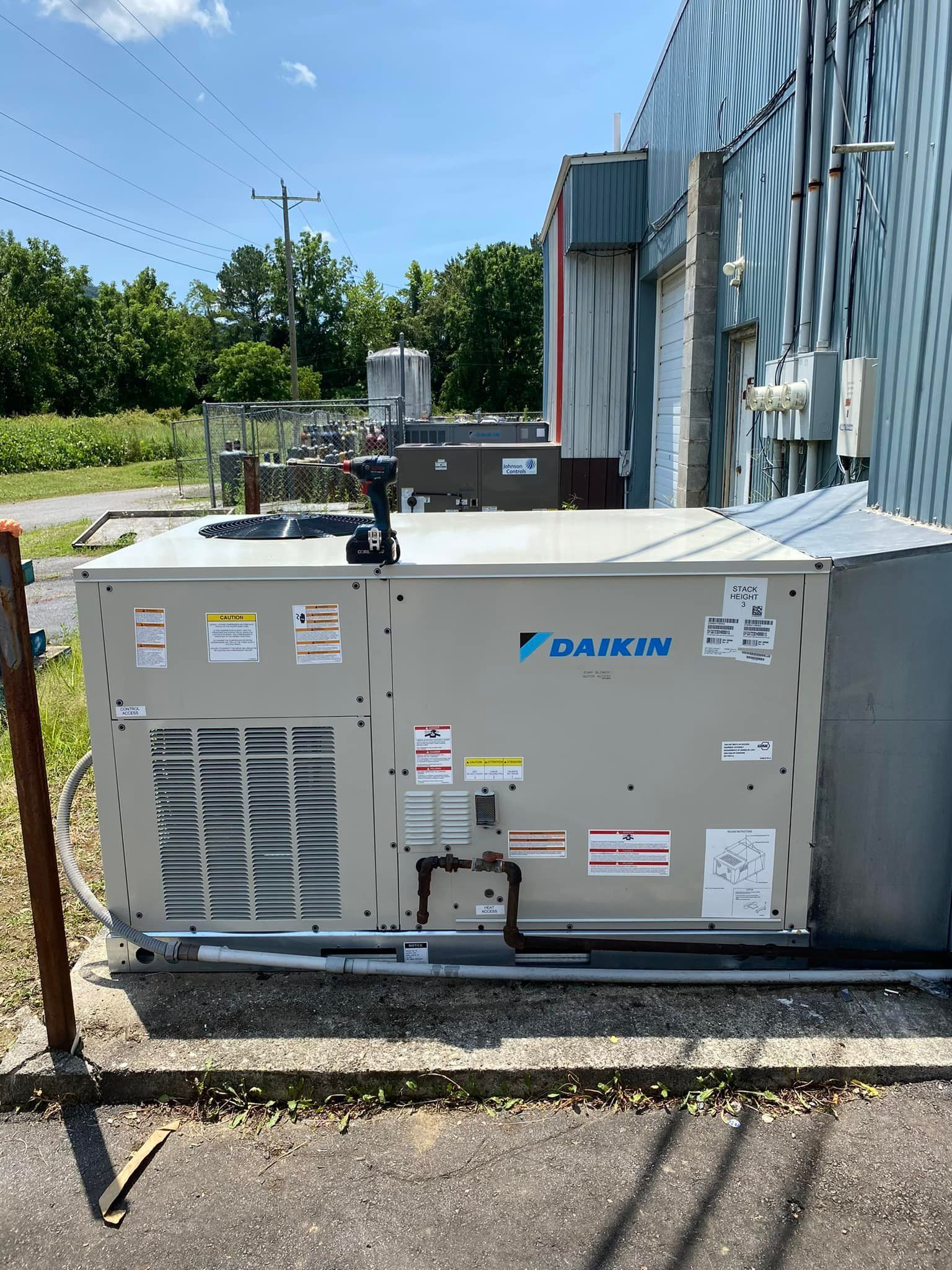 A large air conditioner is sitting outside of a building.