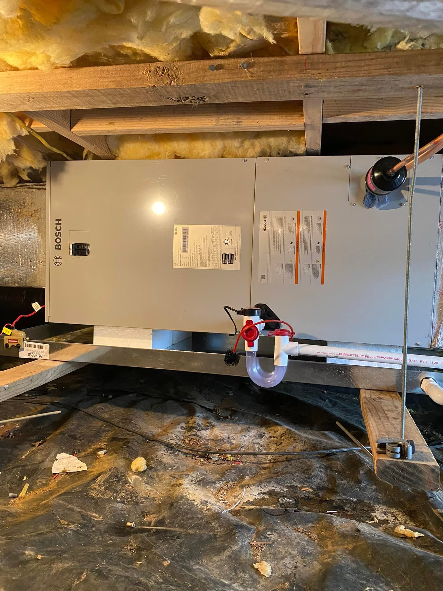 An air conditioner is being installed in a basement.