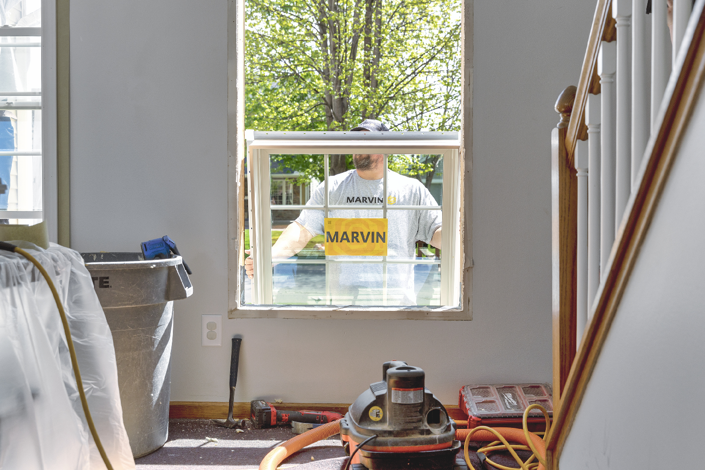 A man is installing a window in a house.