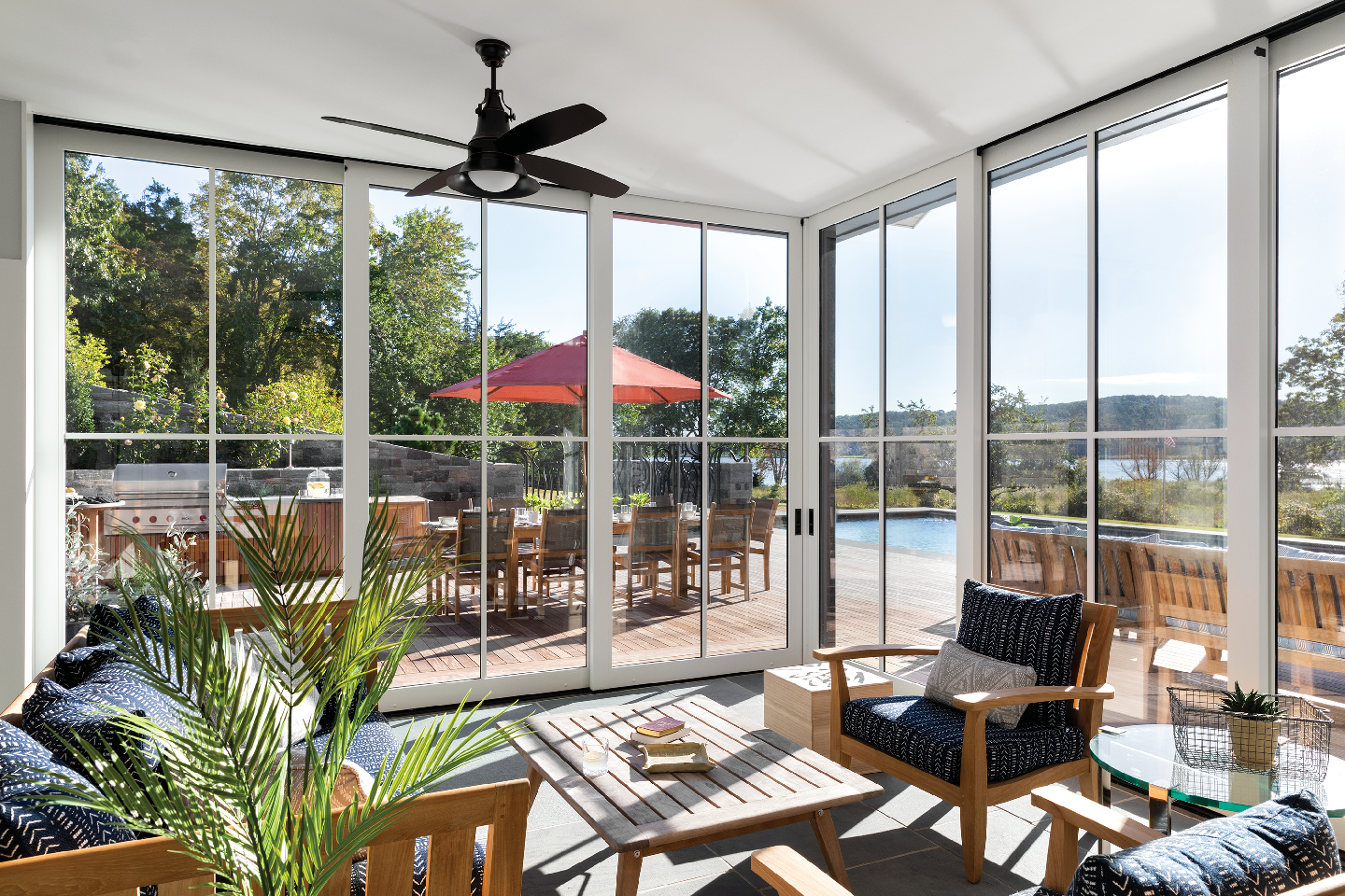 A living room with a lot of windows and a ceiling fan.