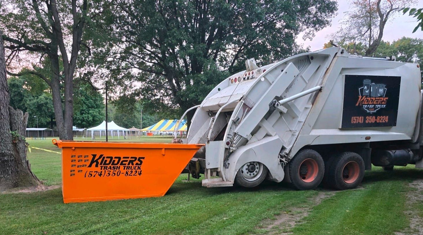Orange Kidder's dumpster in front of a tan corrugated wall and garage door